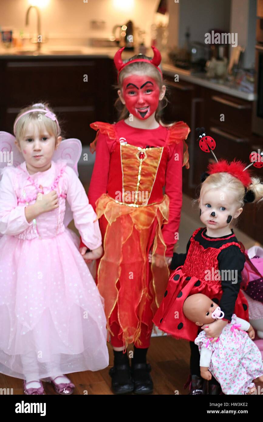 Drei Mädchen Kinder tragen Fee, Teufel und Marienkäfer Kostüme zu Halloween gekleidet Stockfoto