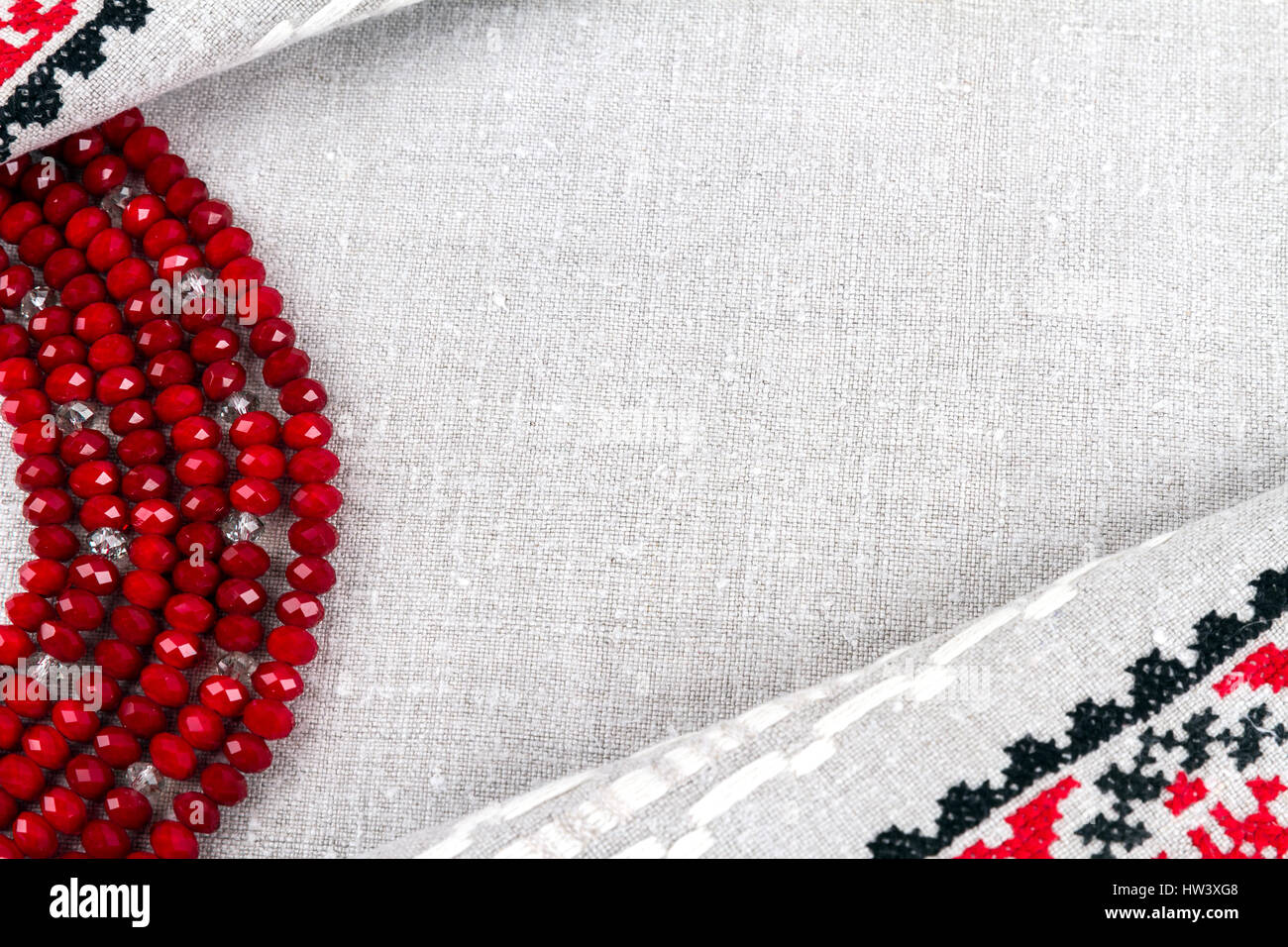 Slawische Kultur: traditionelle weibliche Perlen Granat mit Einschlüssen Bergkristall auf Naturleinen (Tuch) Hintergrund Stockfoto