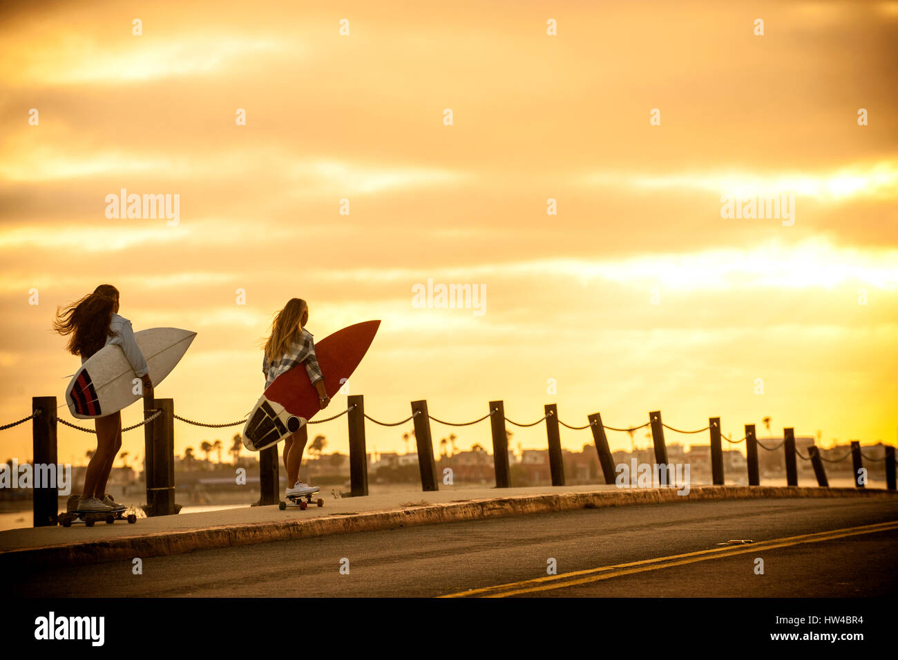 Mädchen im Teenageralter mit Surfbrettern auf skateboards Stockfoto