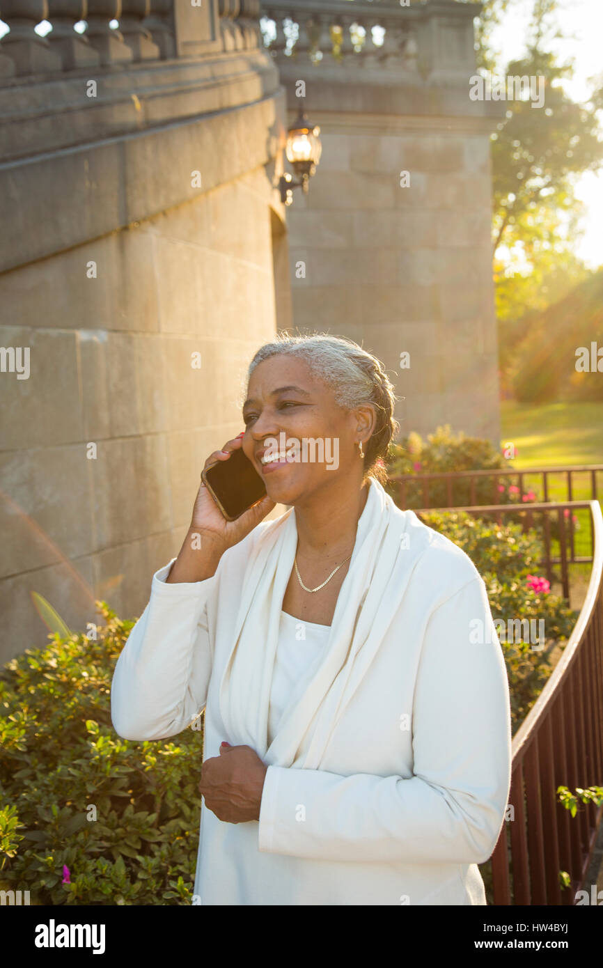 Schwarze Frau am Handy in der Nähe von Steintreppe Stockfoto