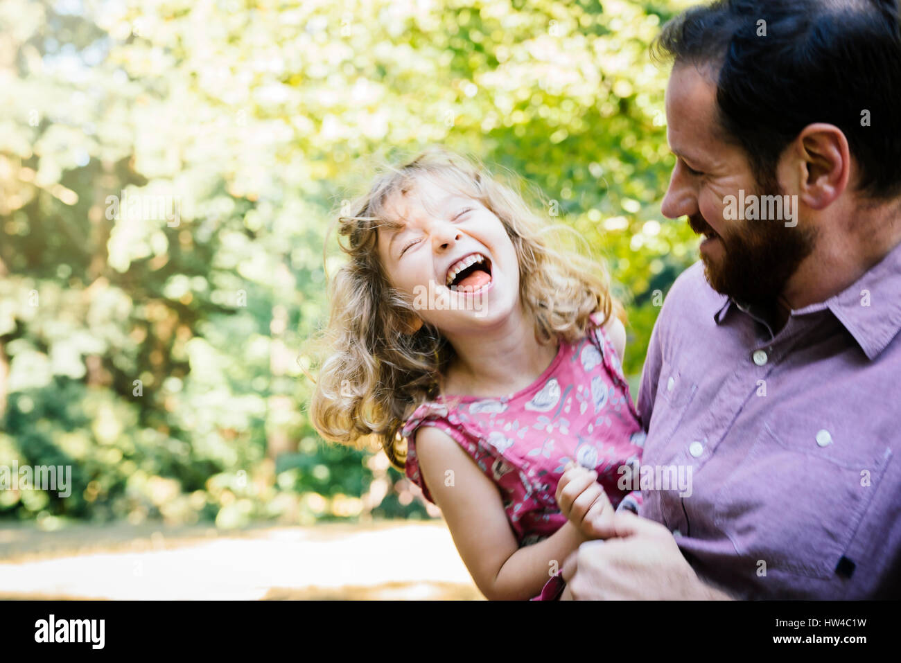 Kaukasische Vater tragen, lachen, Tochter Stockfoto