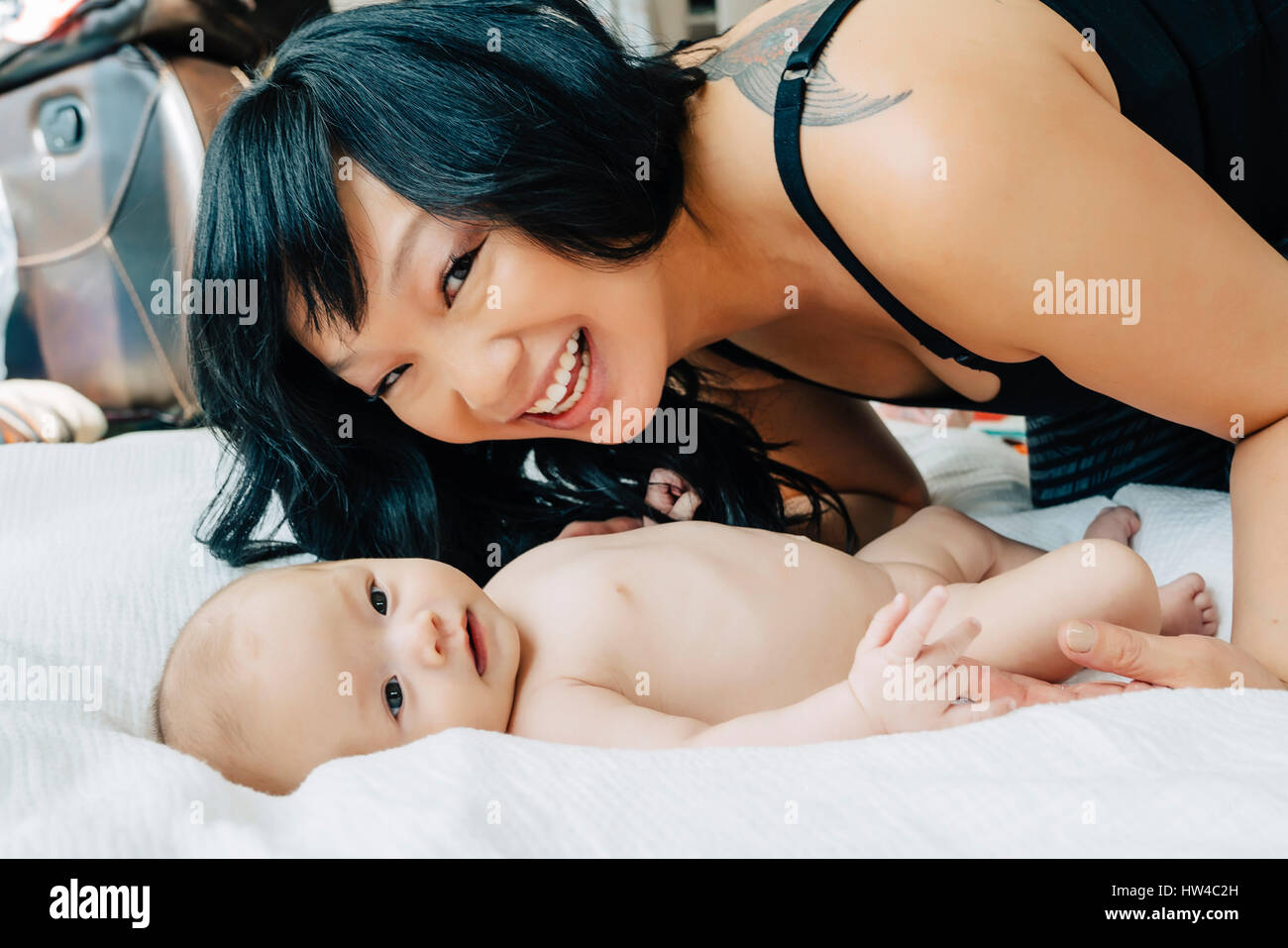 Porträt der Mutter mit Tochter nacktes Baby auf Decke Stockfoto
