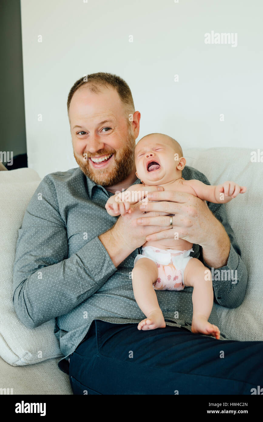 Porträt der lächelnden Vater schreiendes Baby Tochter hielt Stockfoto