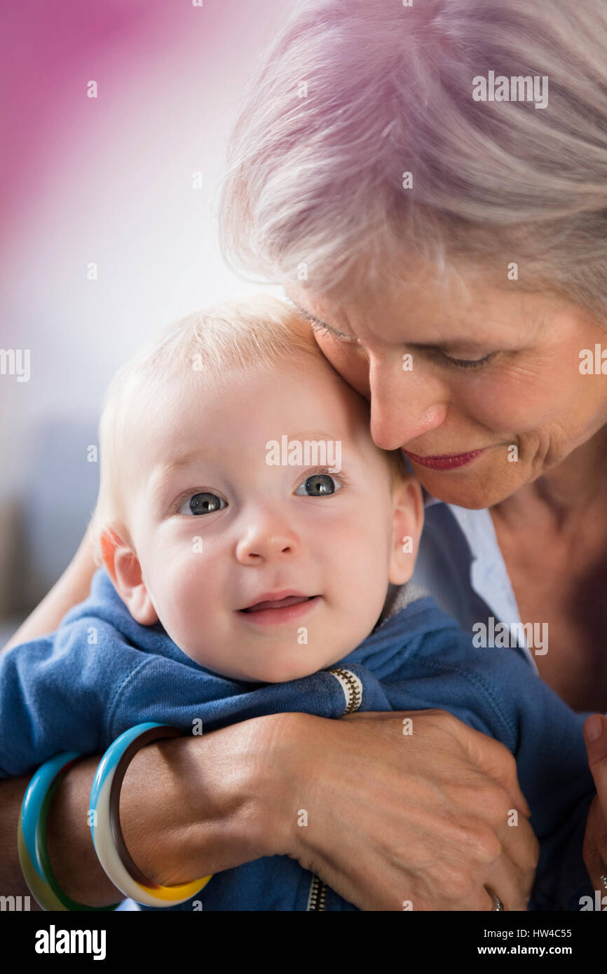 Porträt des Lächelns kaukasischen Großmutter umarmt Baby Enkel Stockfoto