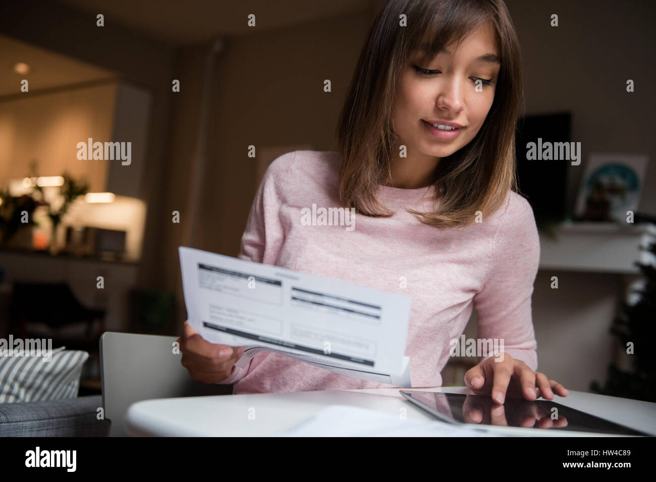 Gemischte Rennen Frau Zahlung von Rechnungen auf digital-Tablette Stockfoto