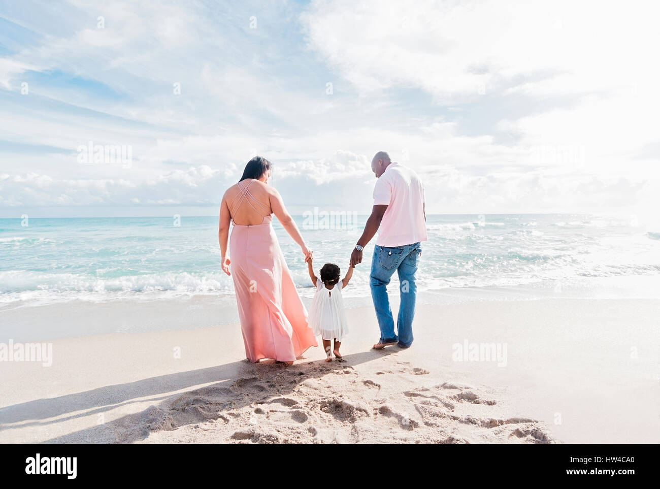 Paar Hand in Hand der Tochter zu Fuß am Strand Stockfoto