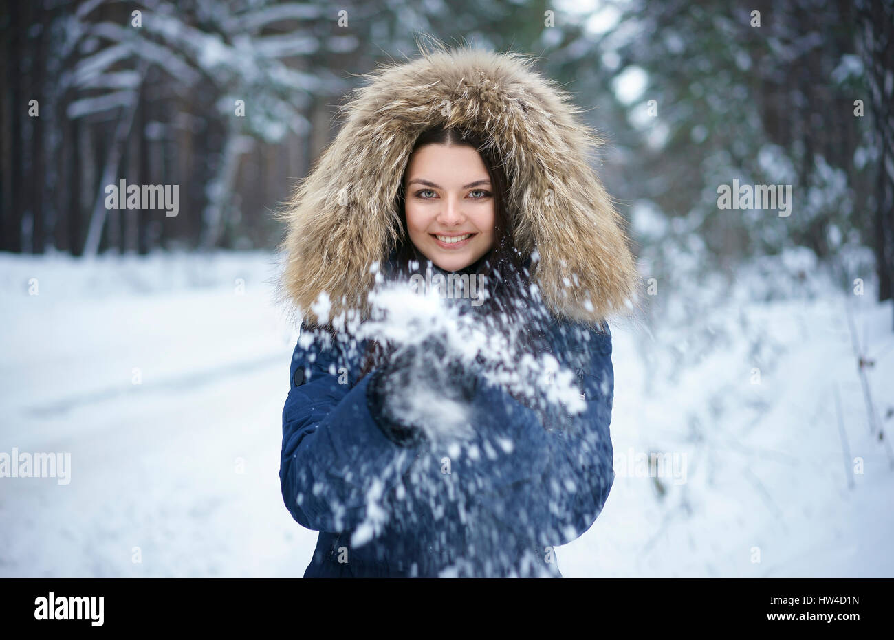 Porträt von verspielten kaukasischen Frau wirft Schnee Stockfoto