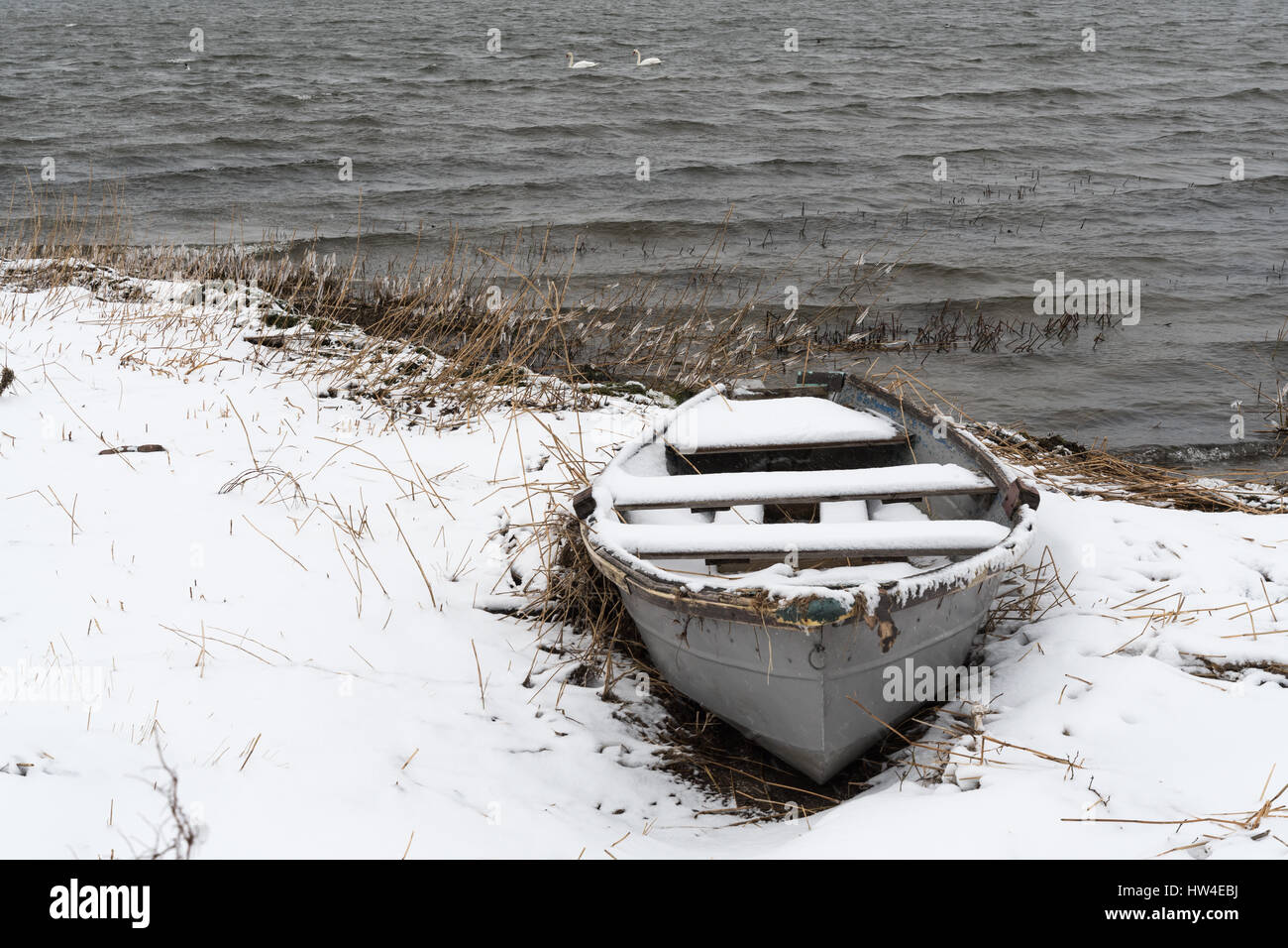 Verschneite alte Ruderboot an der Küste im Wintersaison Stockfoto