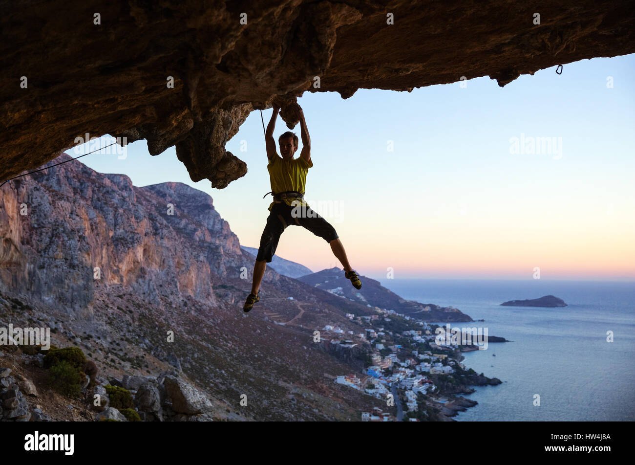 Männliche Kletterer greifen Haltegriff auf der Decke in Höhle und lächelnd Stockfoto