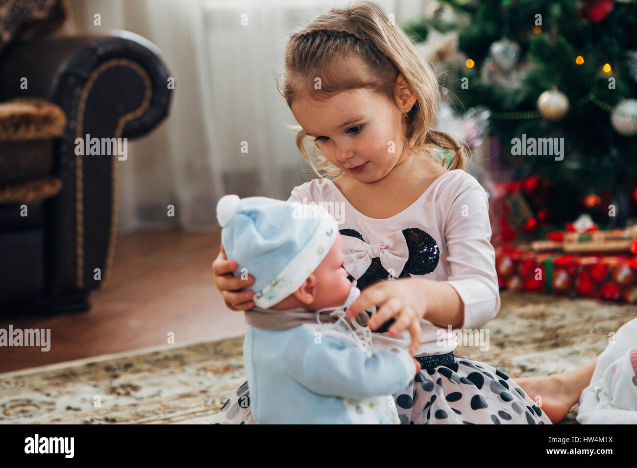 kleines Mädchen öffnet Weihnachtsgeschenk Stockfoto