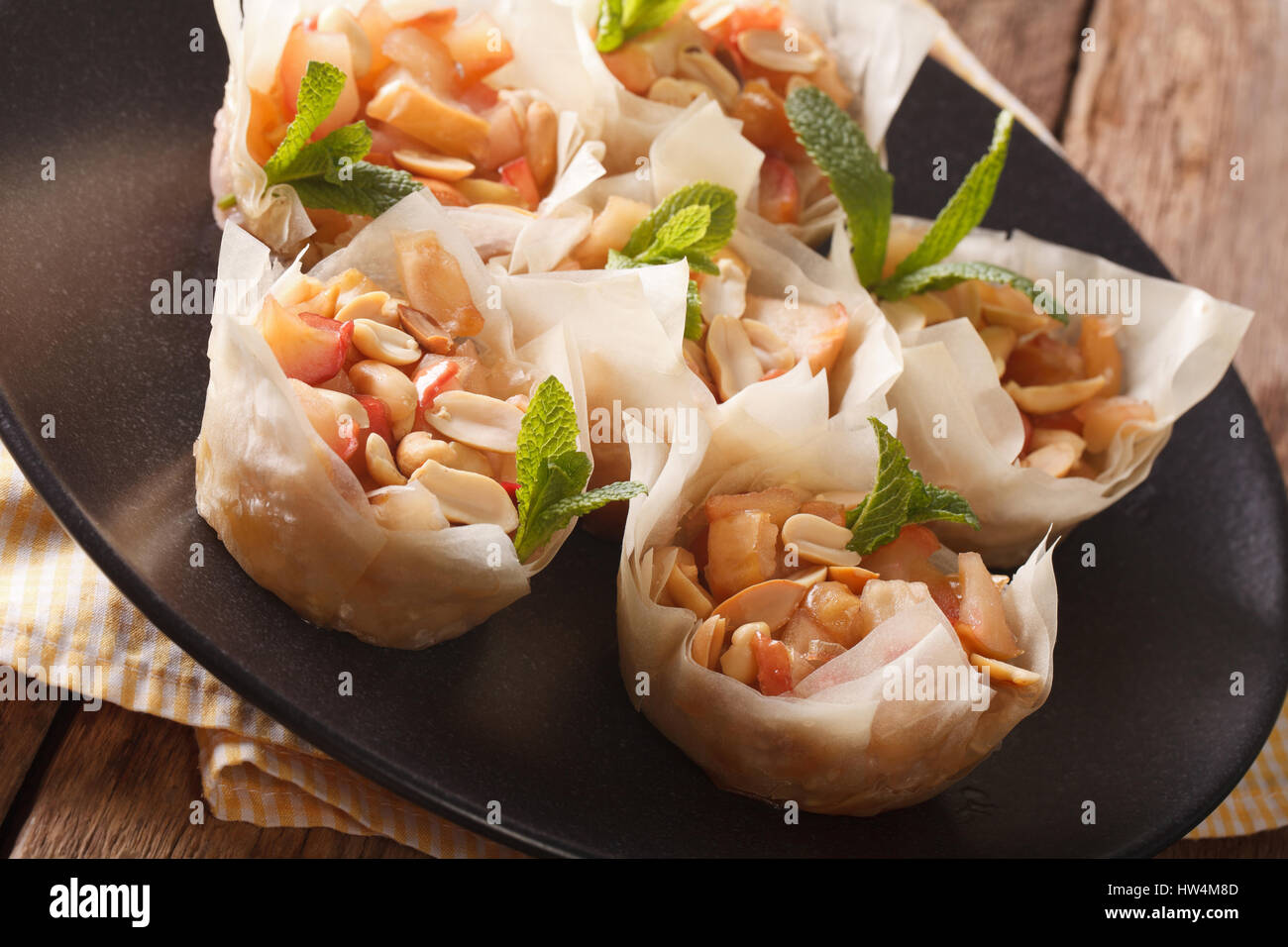 Hausgemachte Mini Phyllo Tassen mit Äpfeln und Nüssen Closeup auf einem Teller. Horizontale Stockfoto
