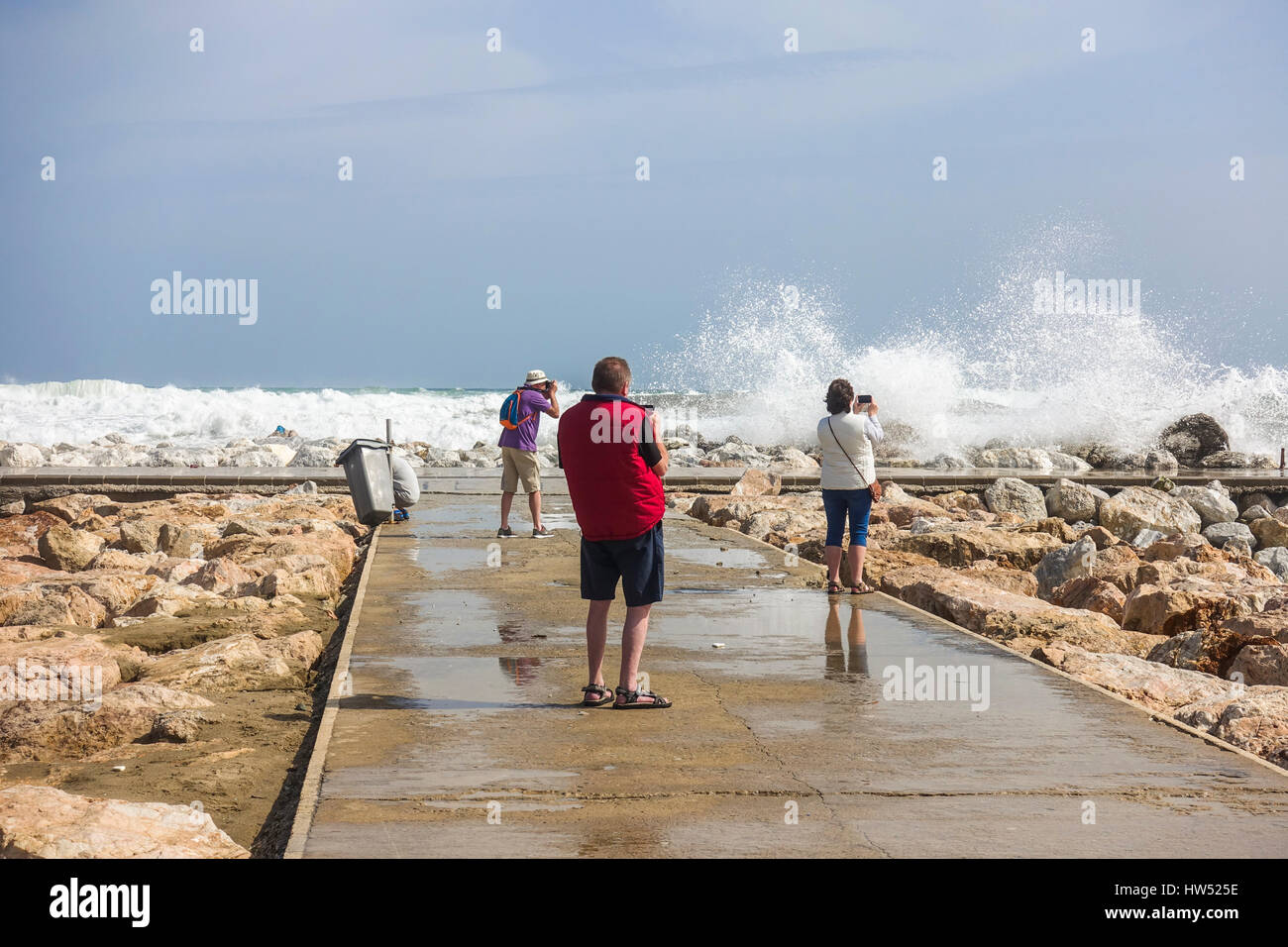 Die Menschen sehen hohe Wellen. Code Orange ist für Gezeiten und Wind gegeben. Fuengirola, Malaga, Andalusien. Spanien Stockfoto