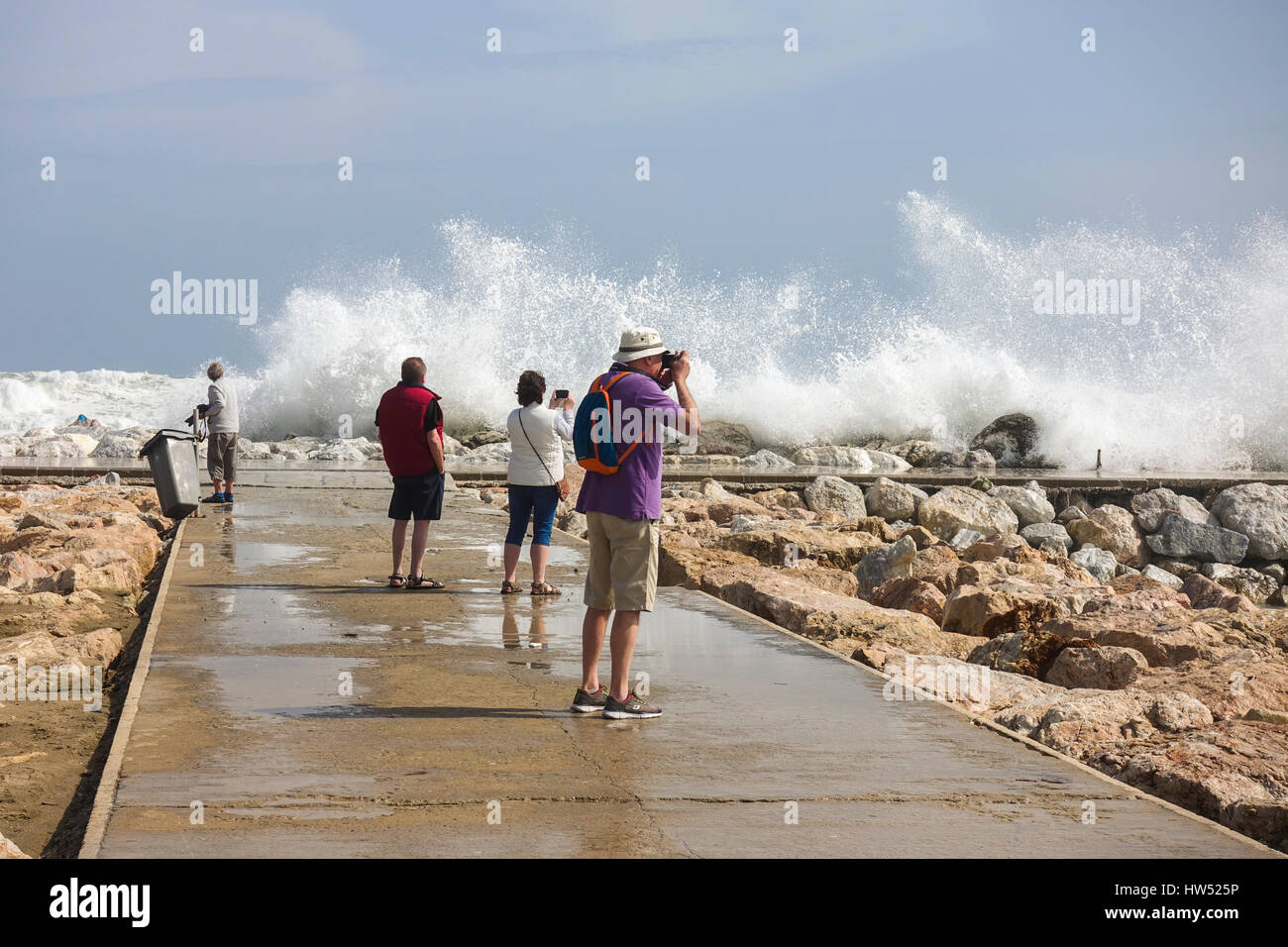 Die Menschen sehen hohe Wellen. Code Orange ist für Gezeiten und Wind gegeben. Fuengirola, Malaga, Andalusien. Spanien Stockfoto