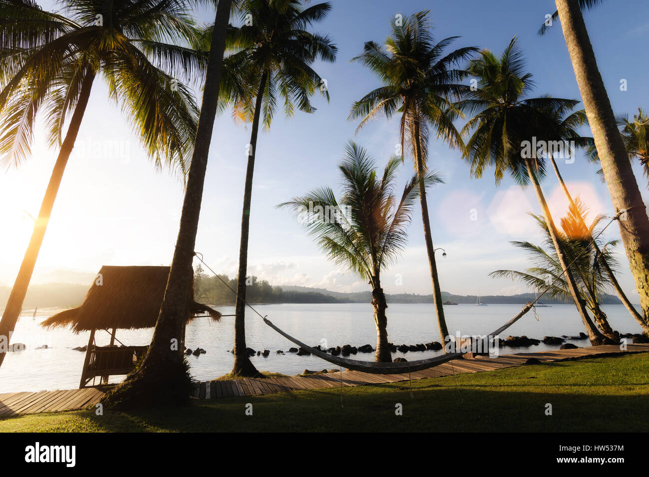 Blick auf den tropischen Strand mit Kokospalmen, Hut und Wiege in Phuket, Thailand. Sommer, Reisen, Urlaub und Ferien-Konzept. Stockfoto