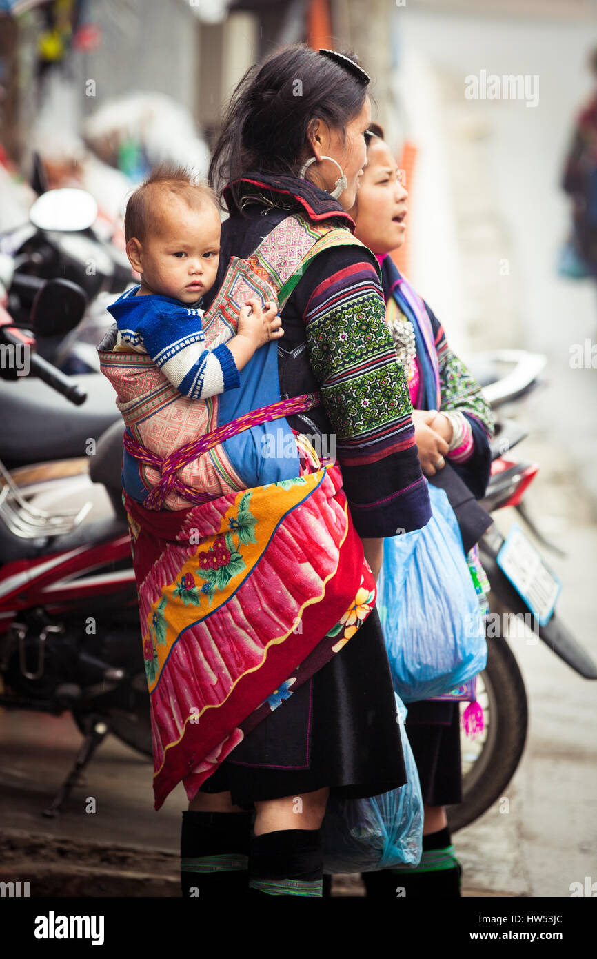 Sapa, Lao Cai, Vietnam - 6. Mai 2014: Ttribal Hmong Frau mit Baby auf der Straße von Sapa, Nord-Vietnam. Stockfoto