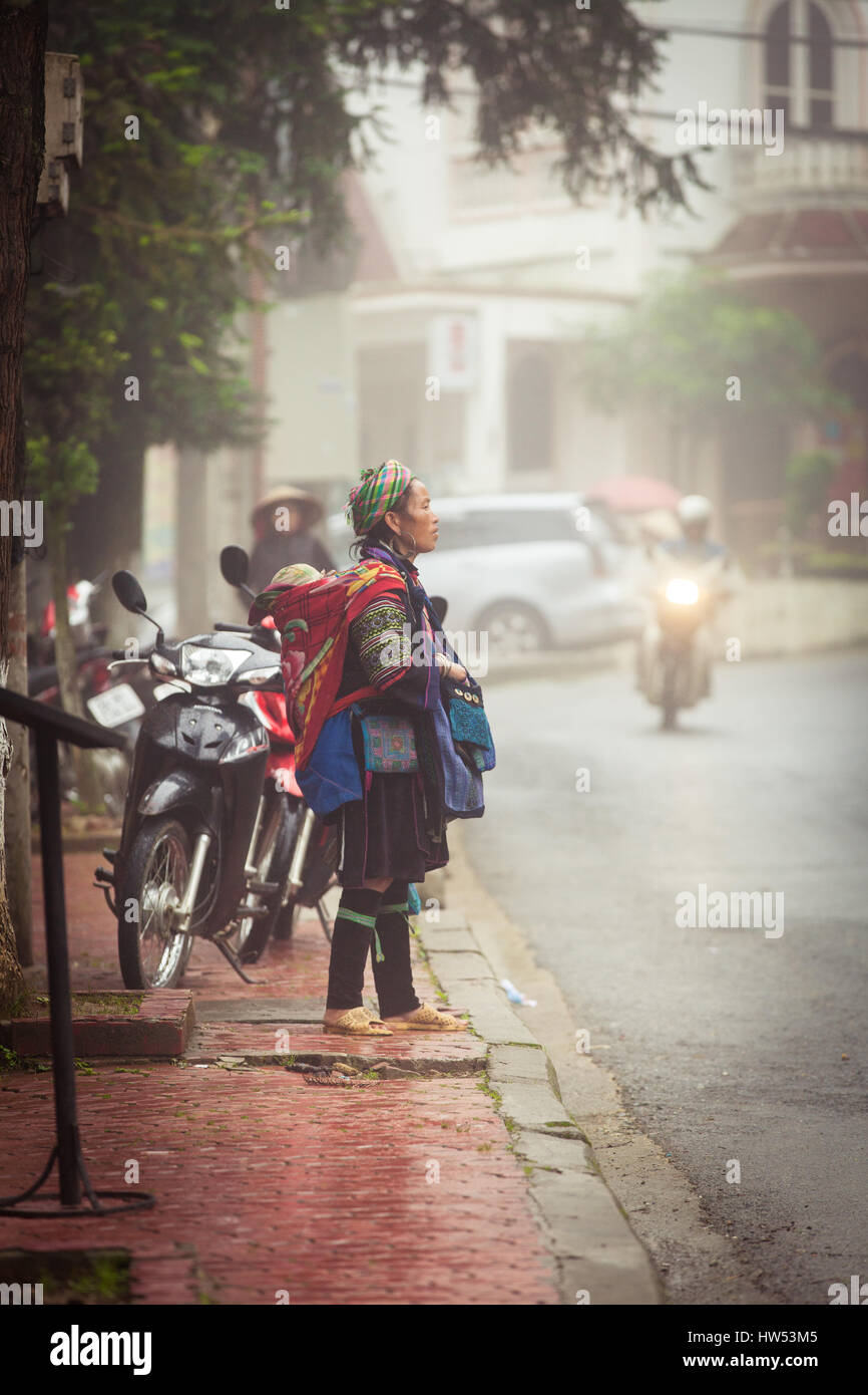 Sapa, Lao Cai, Vietnam - 6. Mai 2014: Ttribal Hmong Frau mit Baby auf der Straße von Sapa, Nord-Vietnam. Stockfoto