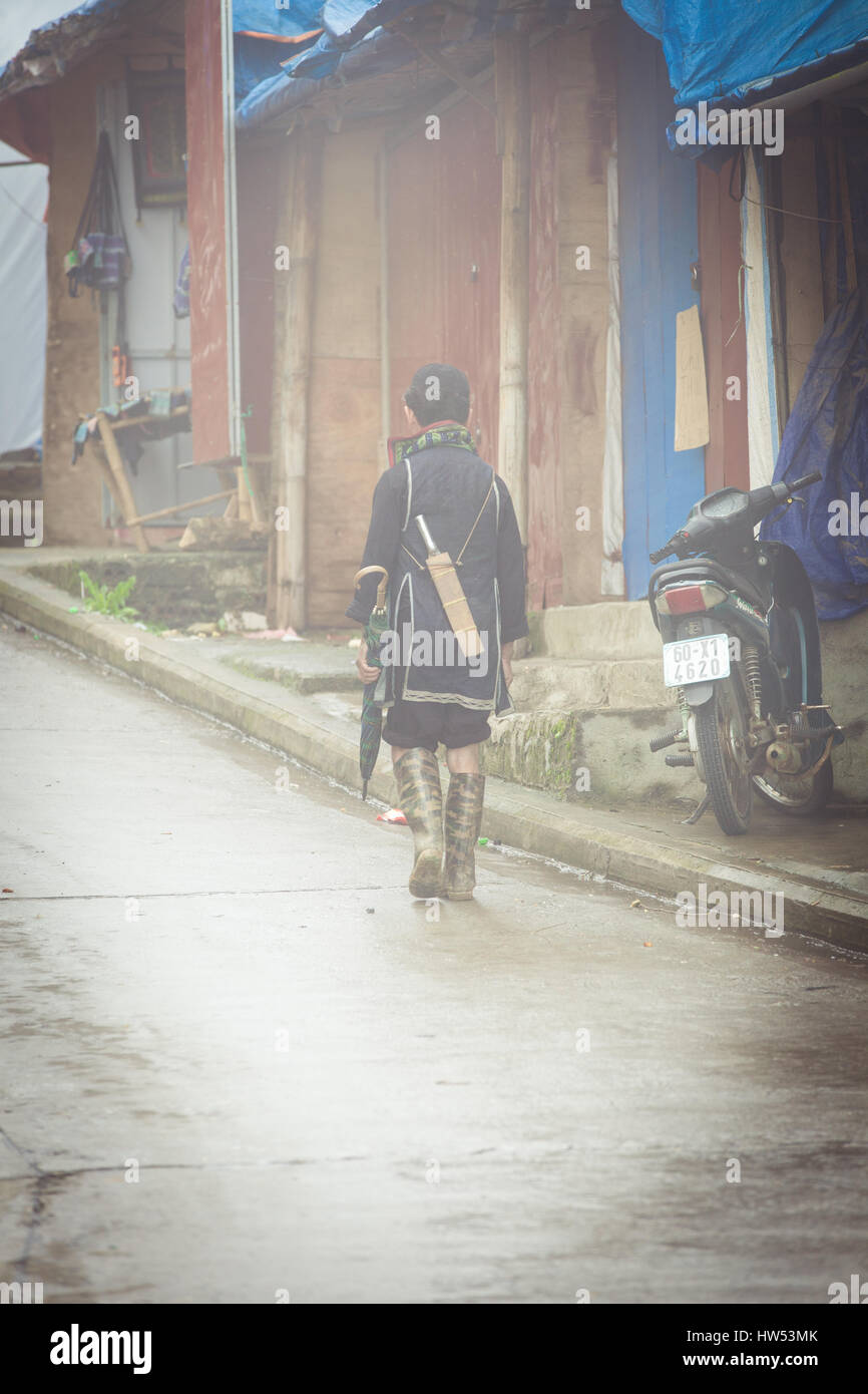 Sapa, Vietnam - 6. Mai 2014: Hmong Mann in traditioneller Kleidung auf der Straße in dichtem Nebel in Sapa Village, Vietnam. Stockfoto
