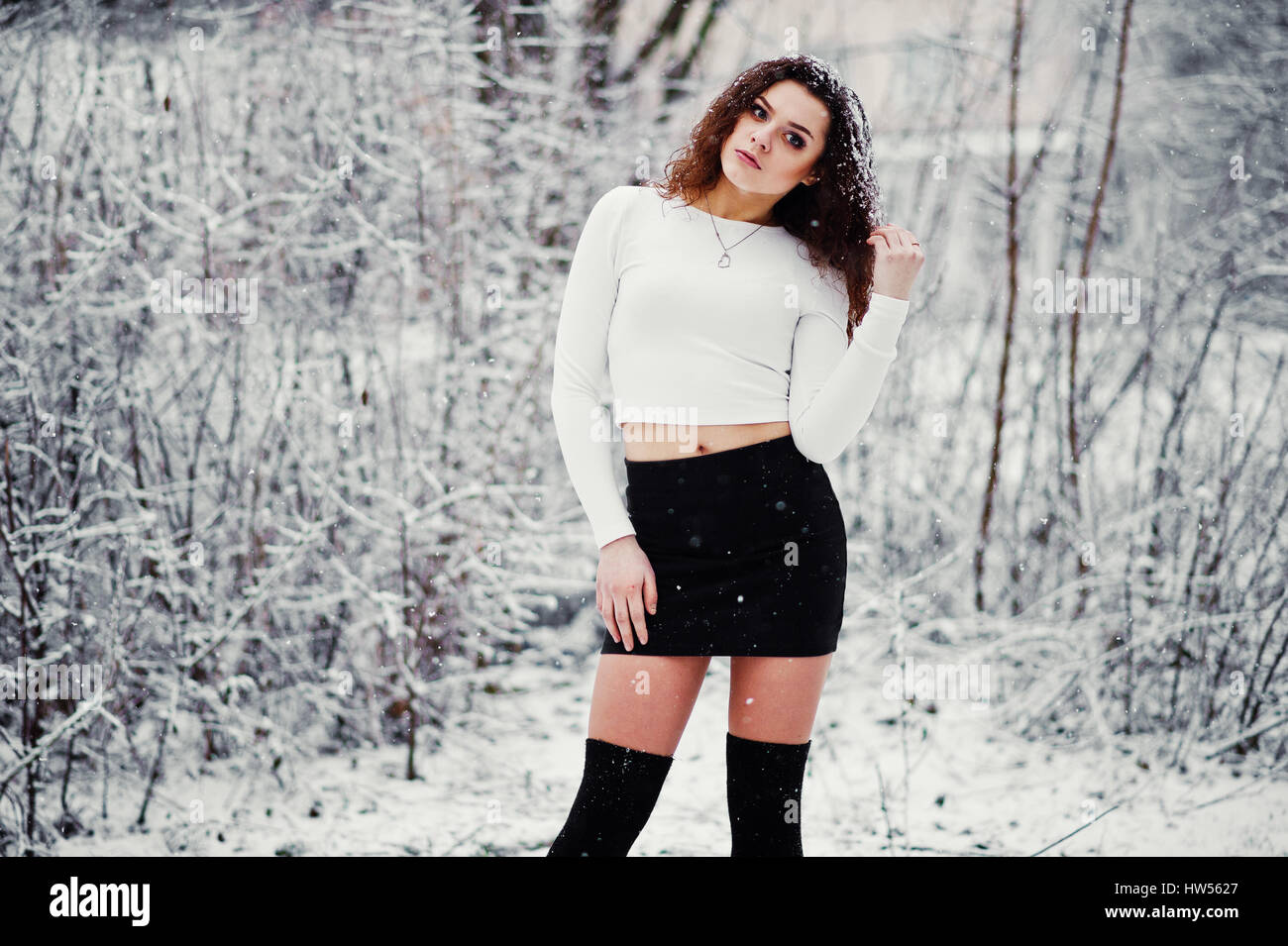 Curly Brünette Mädchen Hintergrund fallenden Schnee, schwarzen Minirock und  Wolle Strümpfe tragen. Modell im Winter. Mode-Portrait bei Schneewetter.  Instagra Stockfotografie - Alamy