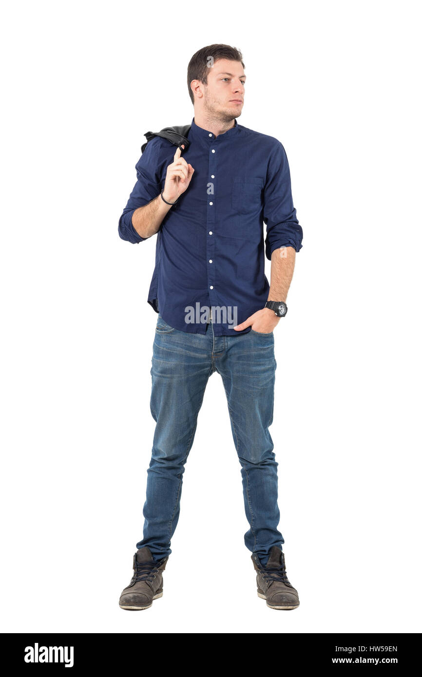 Coole junge Mann im blauen Hemd mit Jacke über die Schulter weg schauen. Ganzkörper-Länge-Porträt über weiße Studio-Hintergrund isoliert. Stockfoto