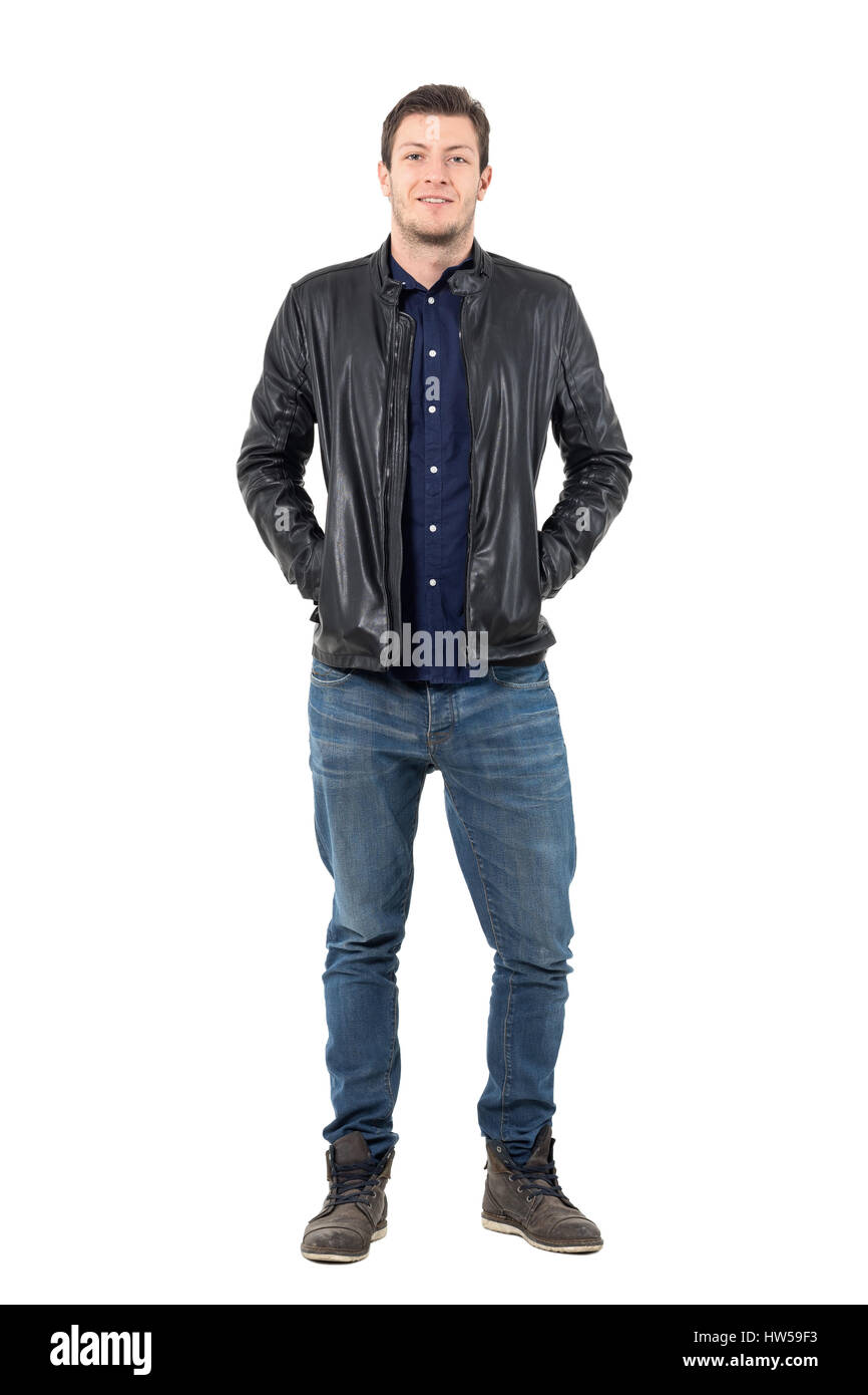 Entspannter Mann in Jeans und Lederjacke lächelnd in die Kamera mit Händen in den Taschen. Ganzkörper-Länge-Porträt über weiße Studio-Hintergrund isoliert. Stockfoto