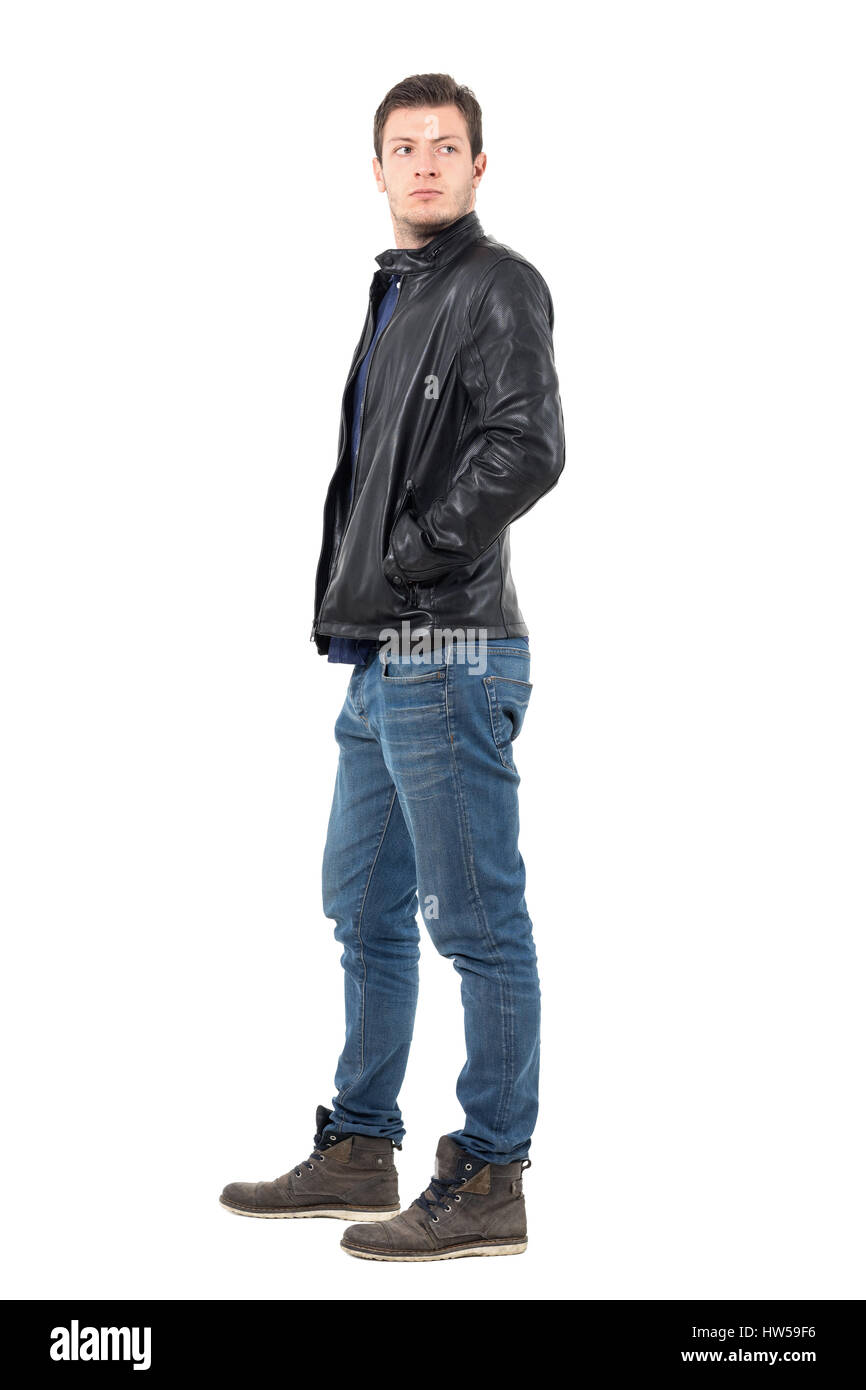 Seitenansicht des Jünglings in Lederjacke und Jeans wieder über die Schulter schauen. Ganzkörper-Länge-Porträt über weiße Studio-Hintergrund isoliert Stockfoto