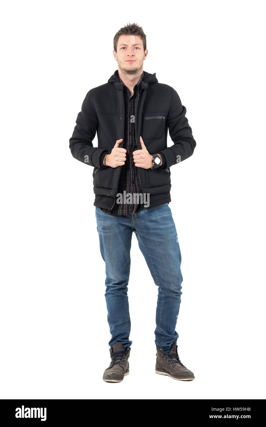 Zuversichtlich lässig junger Mann im schwarzen Kapuzen Winterjacke und Jeans. Ganzkörper-Länge-Porträt über weiße Studio-Hintergrund. Stockfoto