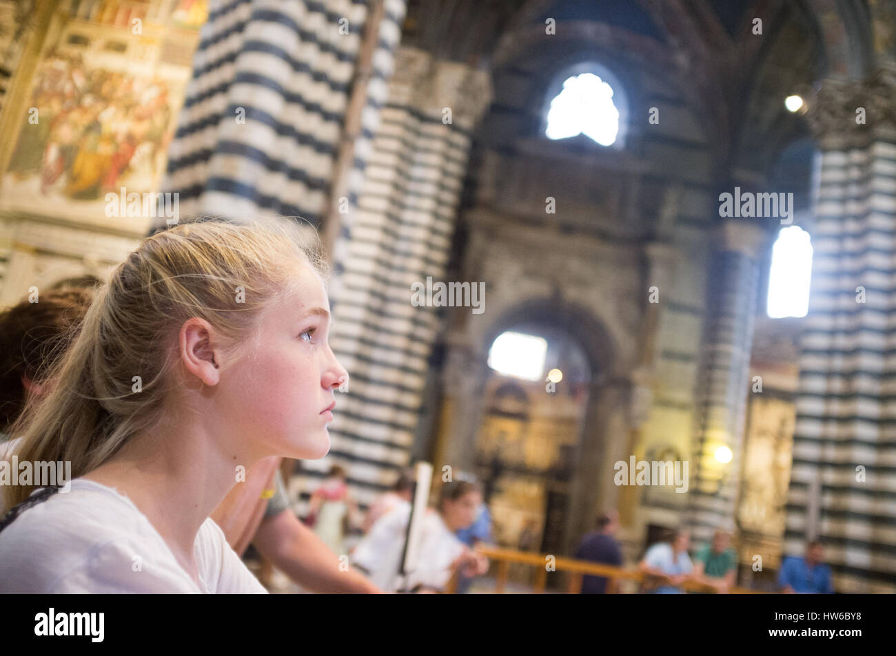 Mädchen, die während einer Tour durch die Kirche in Siena Italien aufschaut Stockfoto