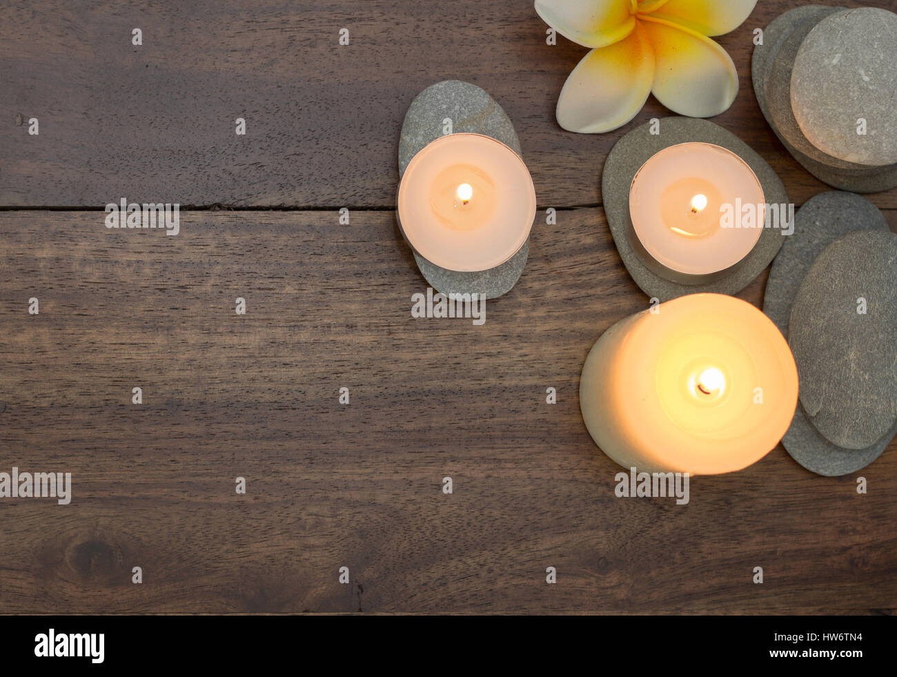 Harmonie-Zen-Zusammensetzung von Steinen und brennenden Kerzen Stockfoto