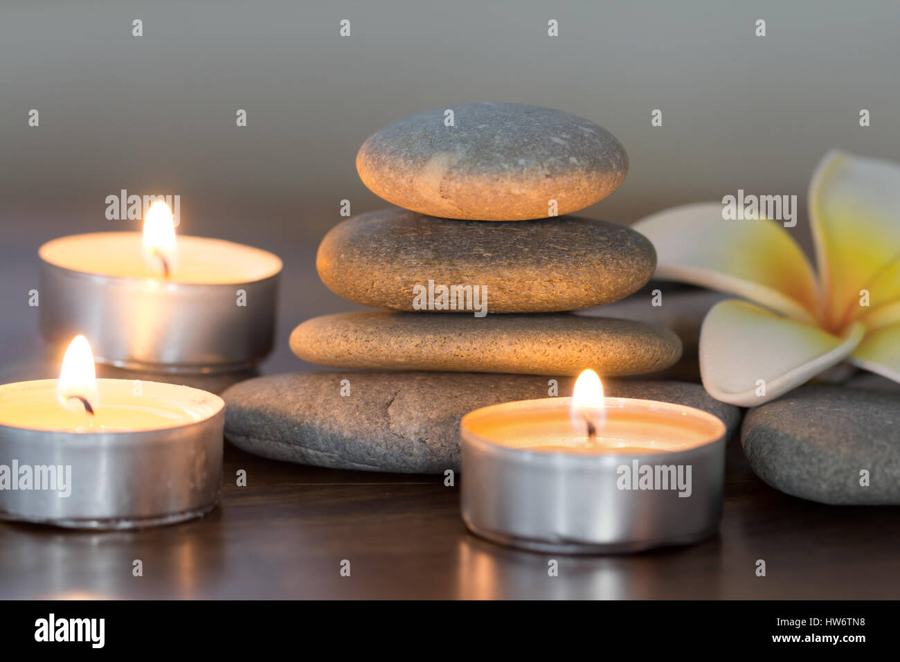Stapel von Kieselsteinen und brennenden Kerzen Stockfoto