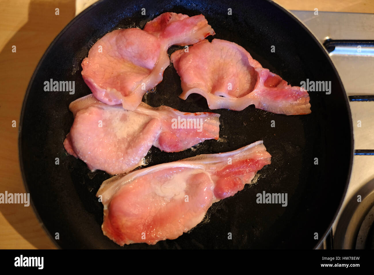 knusprigem Speck in einer Pfanne braten Stockfoto