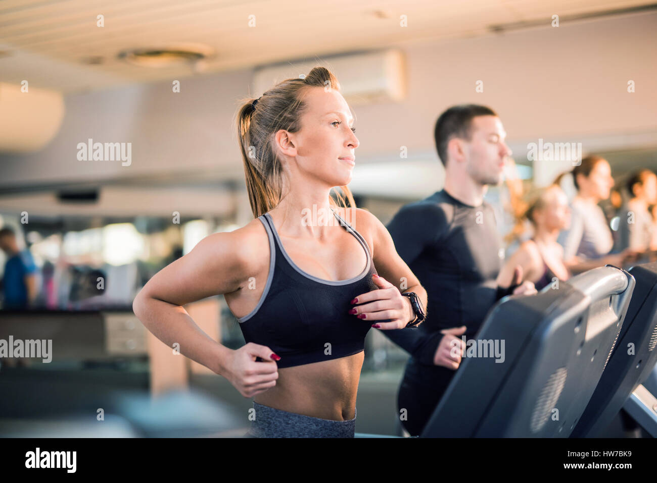 Schöne junge Menschen laufen auf einem Laufband im Fitnessstudio Stockfoto