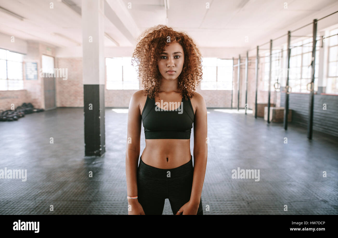 Portrait von junge Afro-Amerikanerin in Sportbekleidung. Fitness-Modell stehen in der Turnhalle und Blick in die Kamera. Stockfoto
