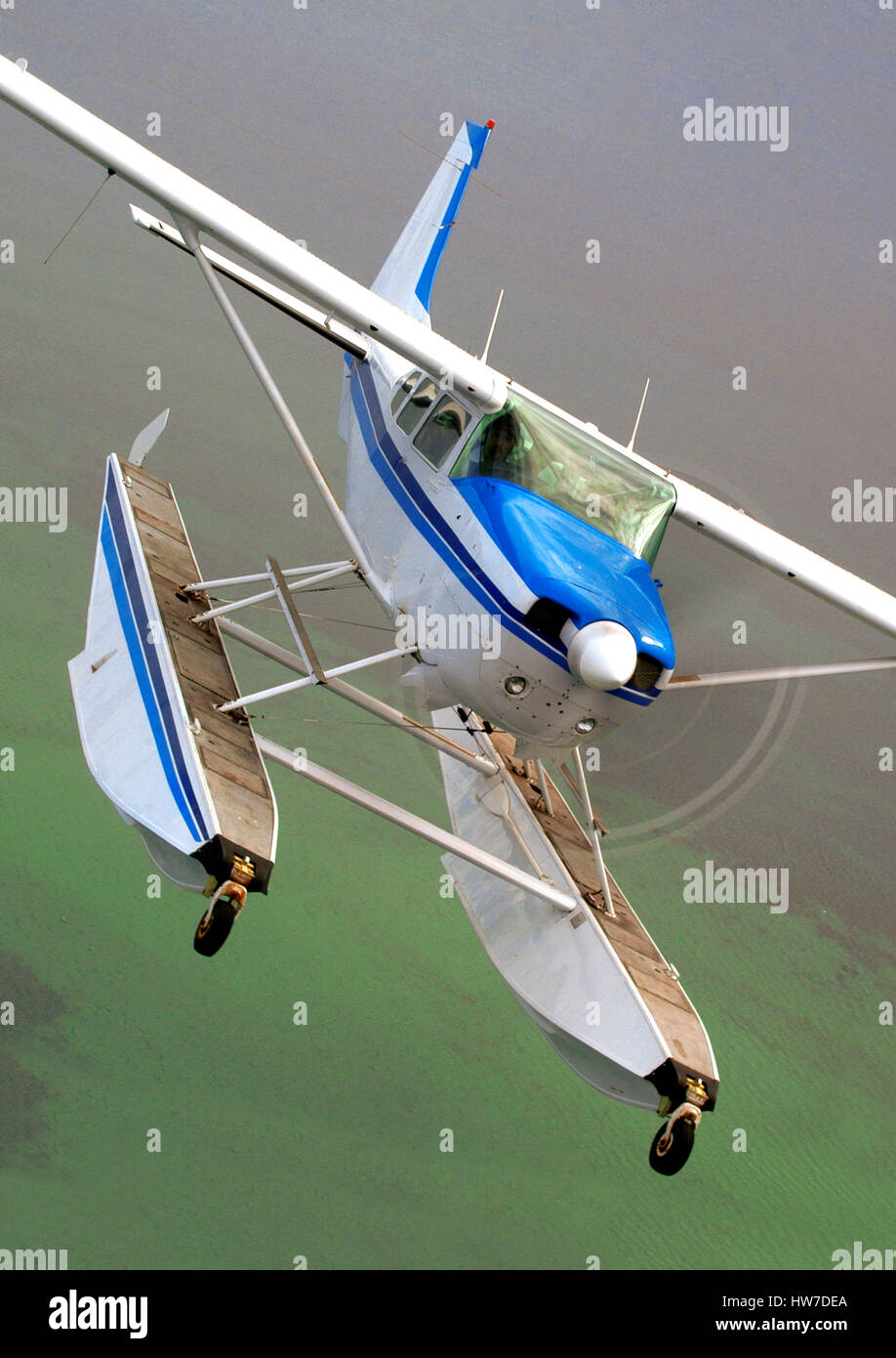 Antenne im Hochformat Float ausgestattet Cessna 206H Stationair Flugzeuge banking in Richtung der Kamera. Stockfoto