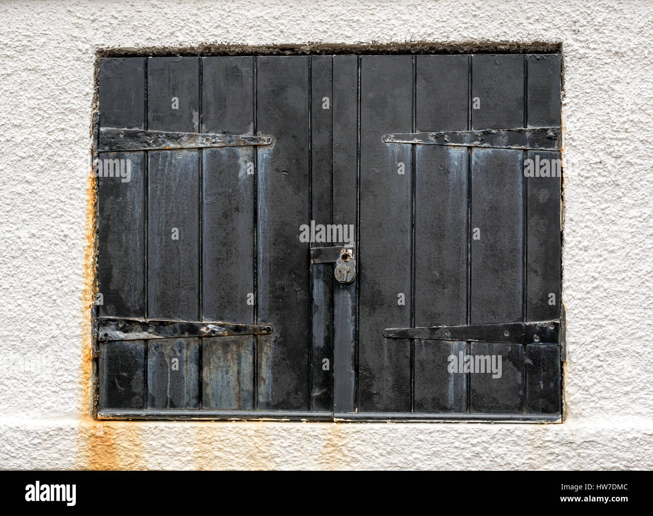 In der Nähe von alten verblasst Schwarz lackiert mit einem Vorhängeschloss geschlossenen Fensters am Meer, North Berwick Hafen, East Lothian, Schottland, Großbritannien Stockfoto