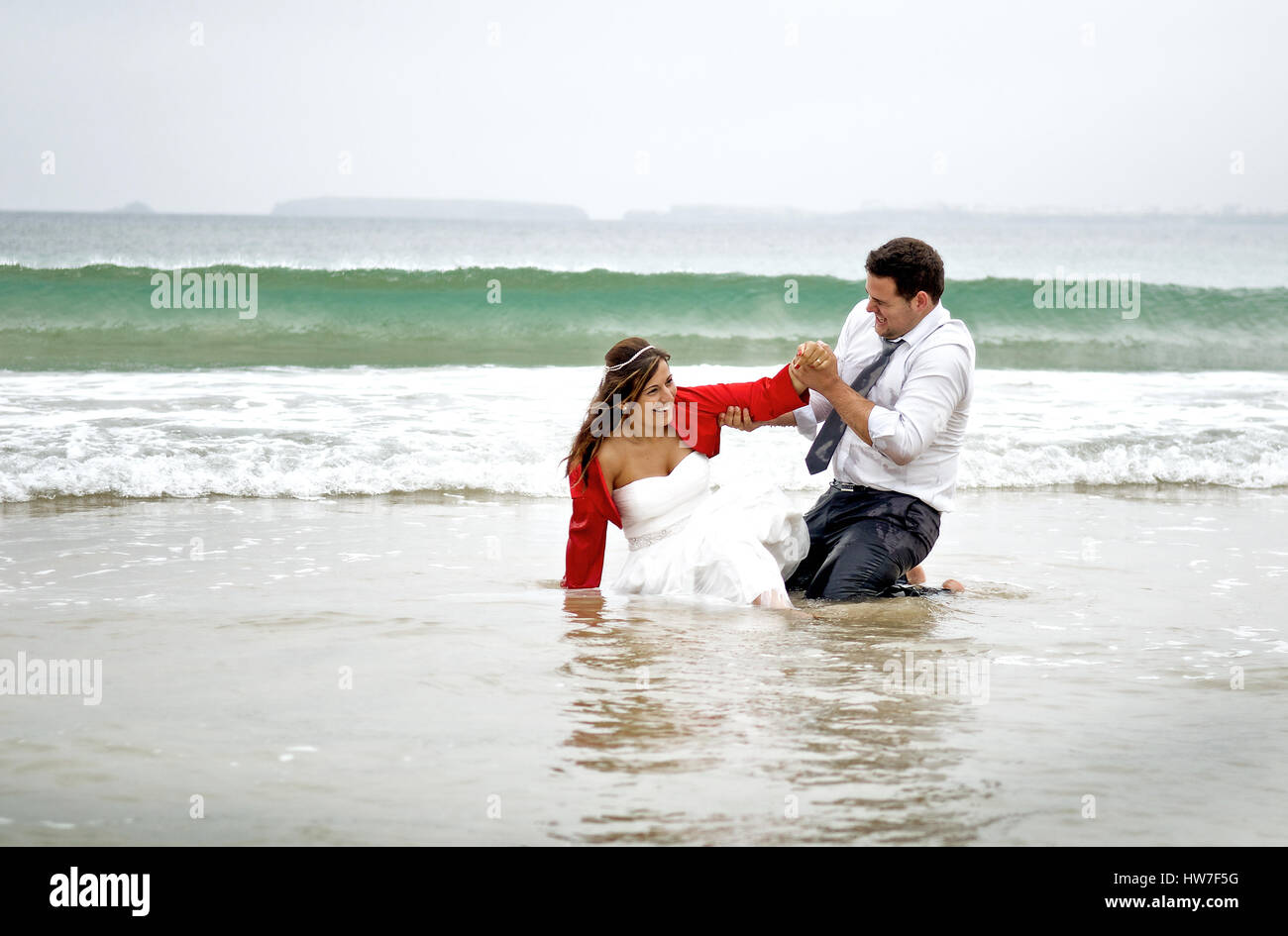 Groom´s paar spielen im Meerwasser Stockfoto