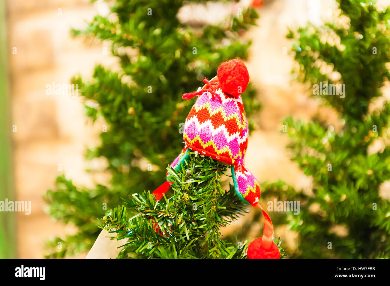 Eine kleine rote Kinder Hut hängen, einen Weihnachtsbaum auf einem hellen grünen Hintergrund Stockfoto