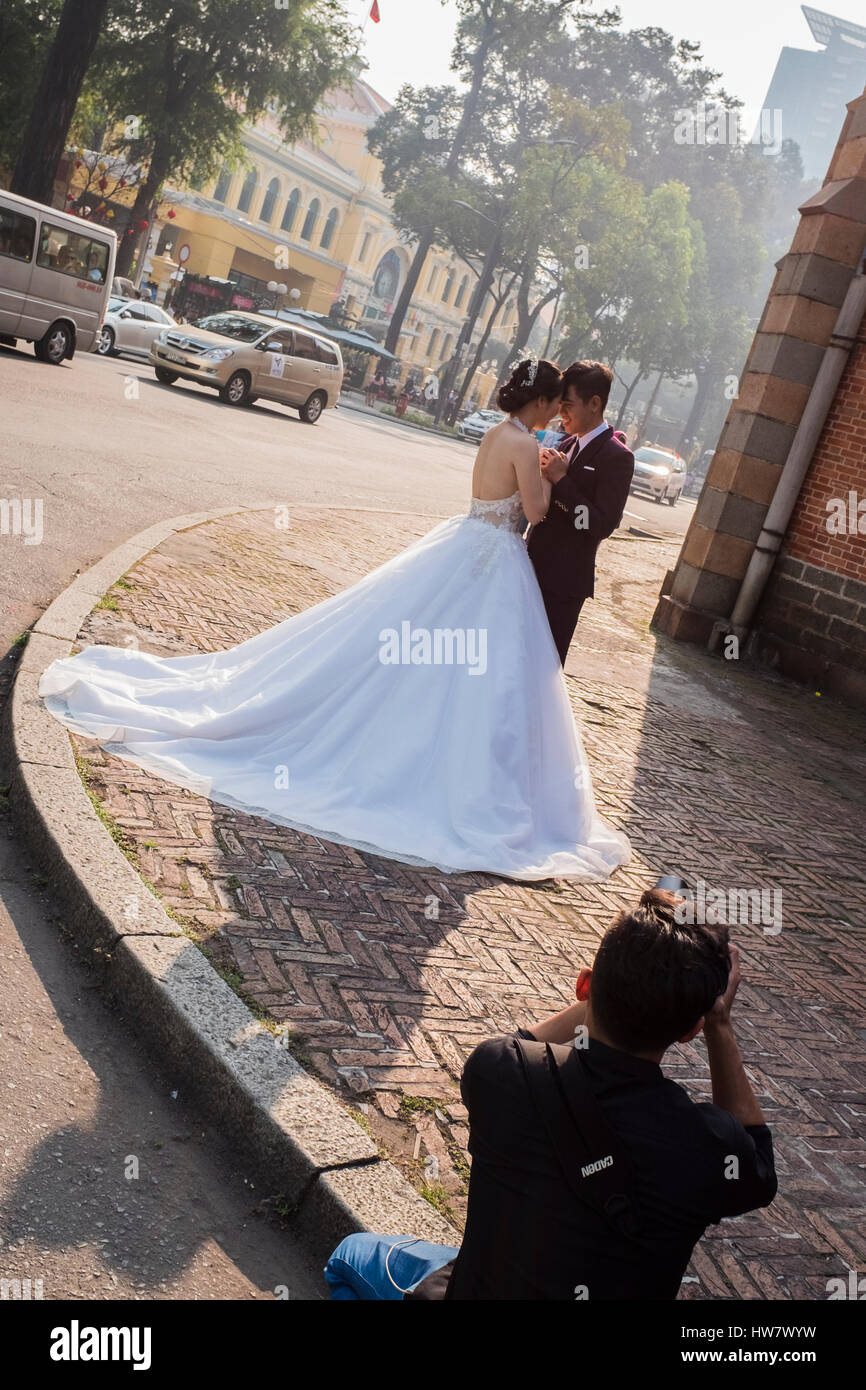 Bräutigam die Braut & Pose Fotografieren außerhalb der Kathedrale, Ho-Chi-Minh-Stadt, Vietnam Stockfoto