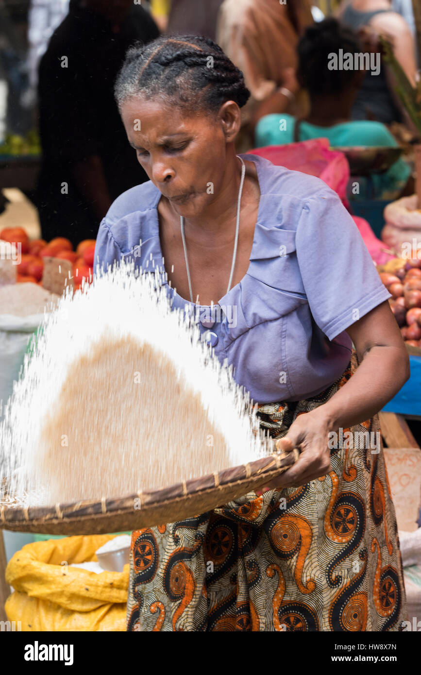 Madagaskar, Nosy werden (Big Island) an der Nordwestküste von Madagaskar Festland. Hellville Markt, Frau bläst auf Reis zu reinigen. Stockfoto