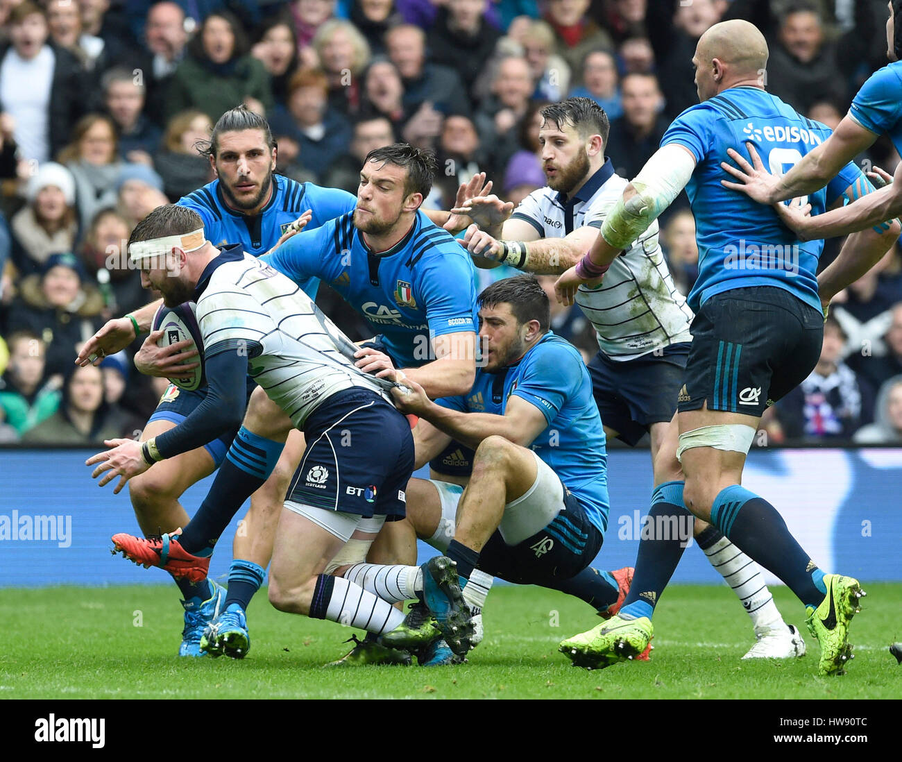 Schottlands Finn Russell Besitz Italiens Edoardo Padovani und Edoardo Gori während der RBS Six Nations Match bei BT Murrayfield, Edinburgh. Stockfoto