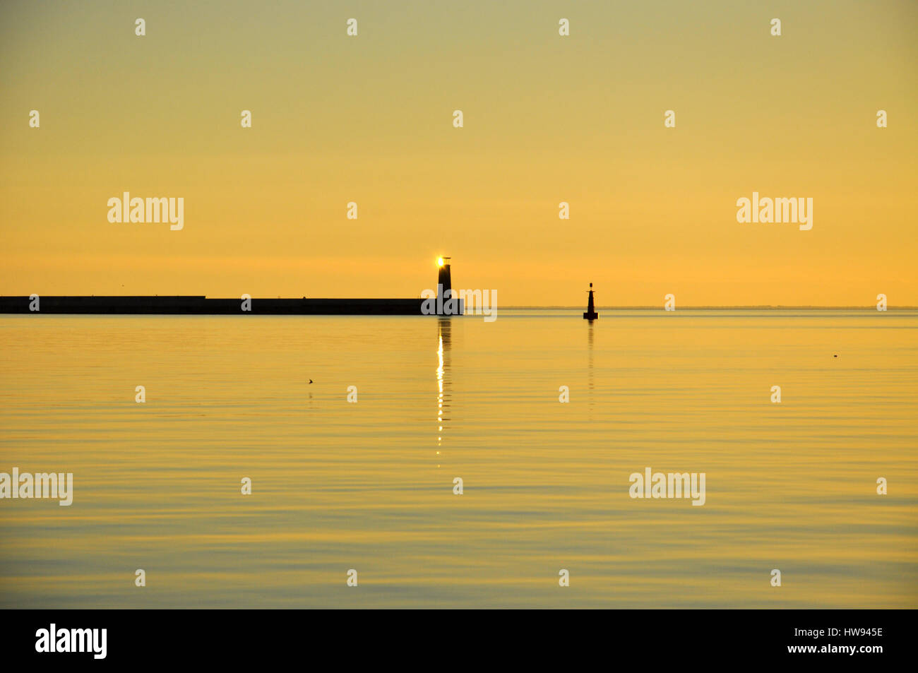 Minimalistische Sonnenaufgang in Pastellfarben. Sonnenaufgang über der Ostsee mit Leuchtturm in Polen Stockfoto