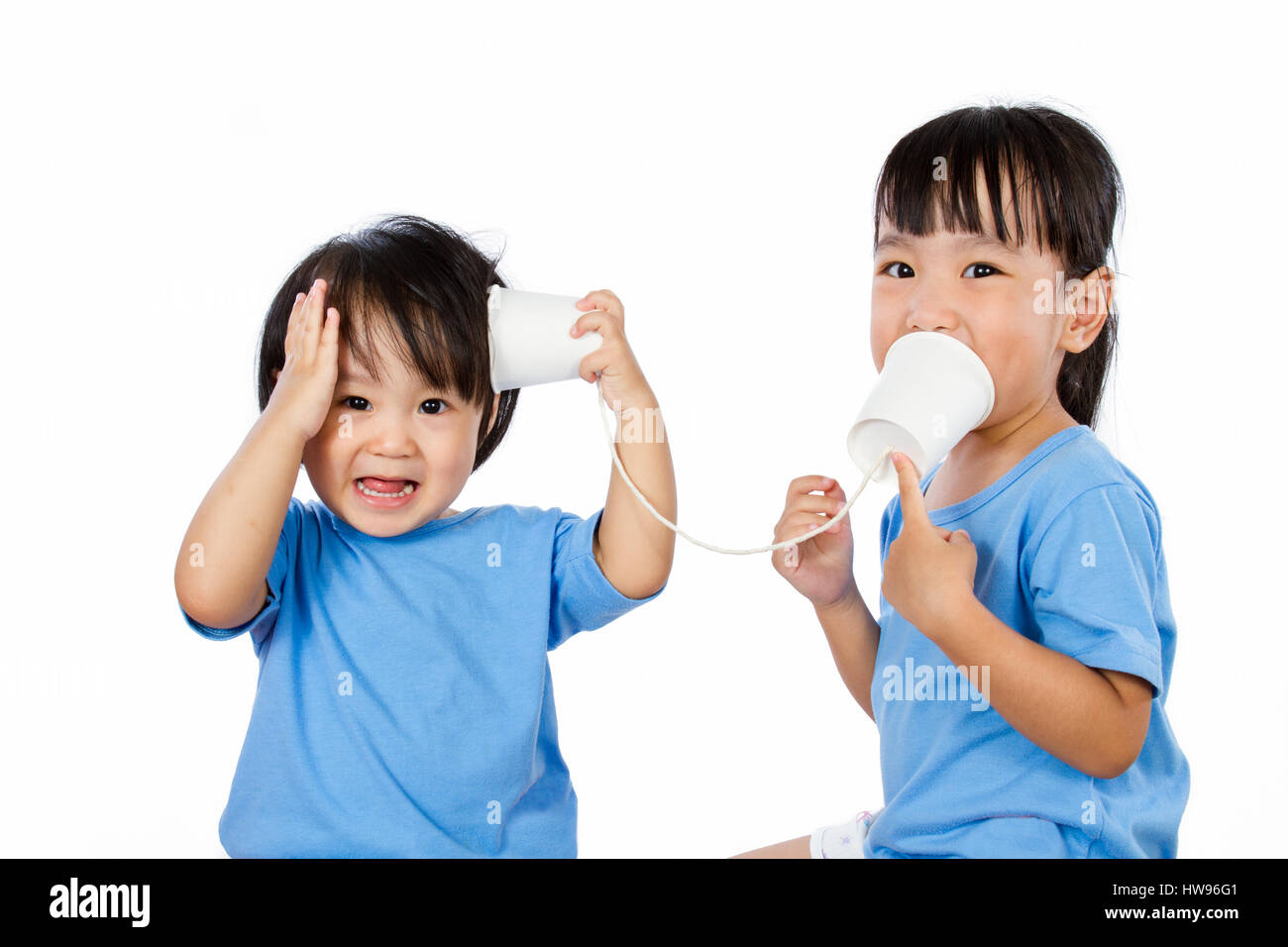 Asiatische kleine chinesische Mädchen spielen mit Pappbecher isoliert auf weißem Hintergrund Stockfoto