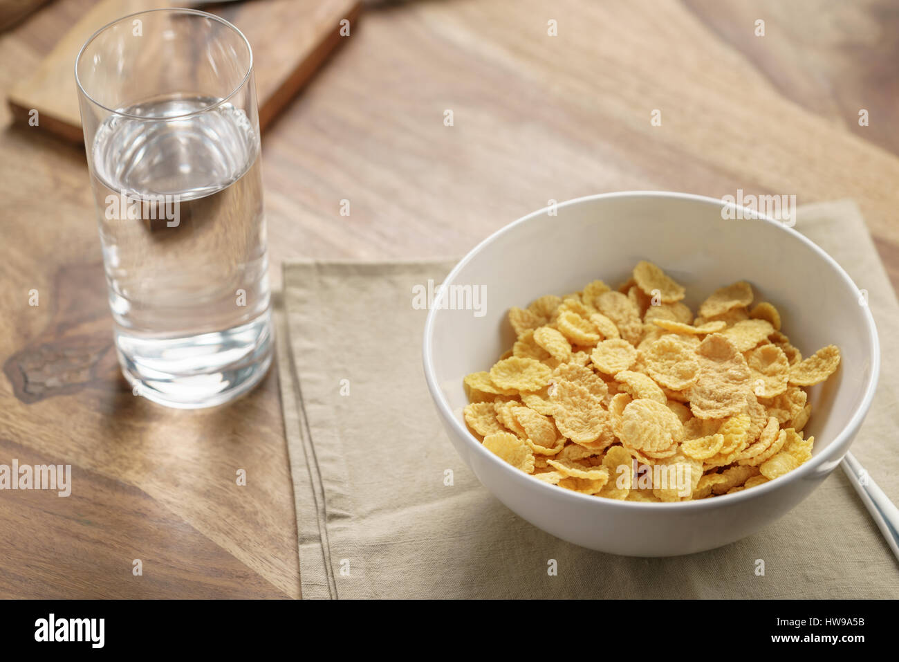 trockene Cornflakes zum Frühstück in Schüssel auf Tisch Stockfoto