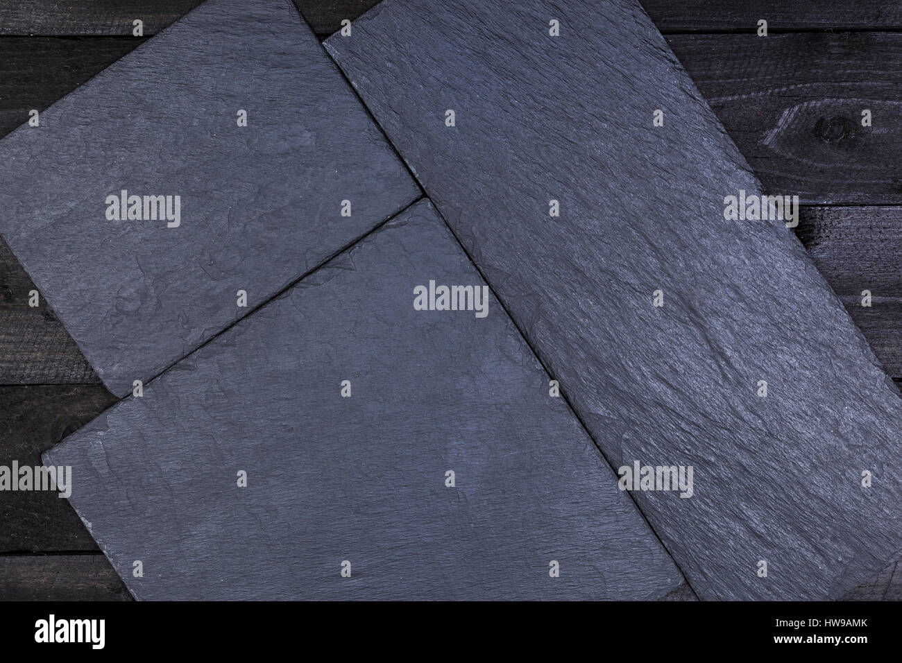 Schiefer Steinplatte auf dunklen Holztisch, Ansicht von oben mit Textfreiraum Stockfoto
