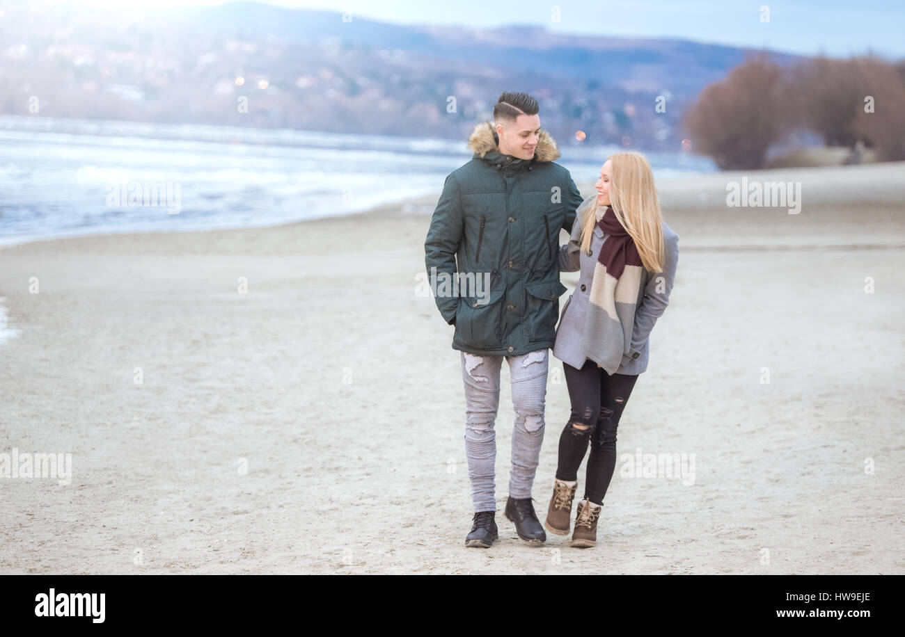 Junge glückliche Paar zu Fuß neben dem Ufer Stockfoto