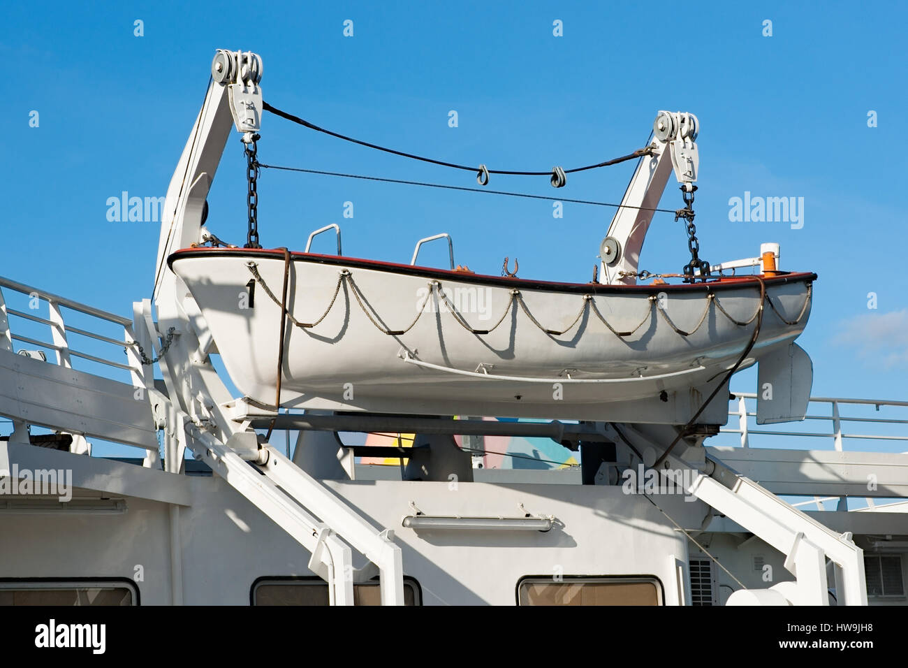 Weiße Rettungsboot hängt an einer Boot-Winde eines Schiffes oder Schiff. Blauen Himmel im Hintergrund. Stockfoto