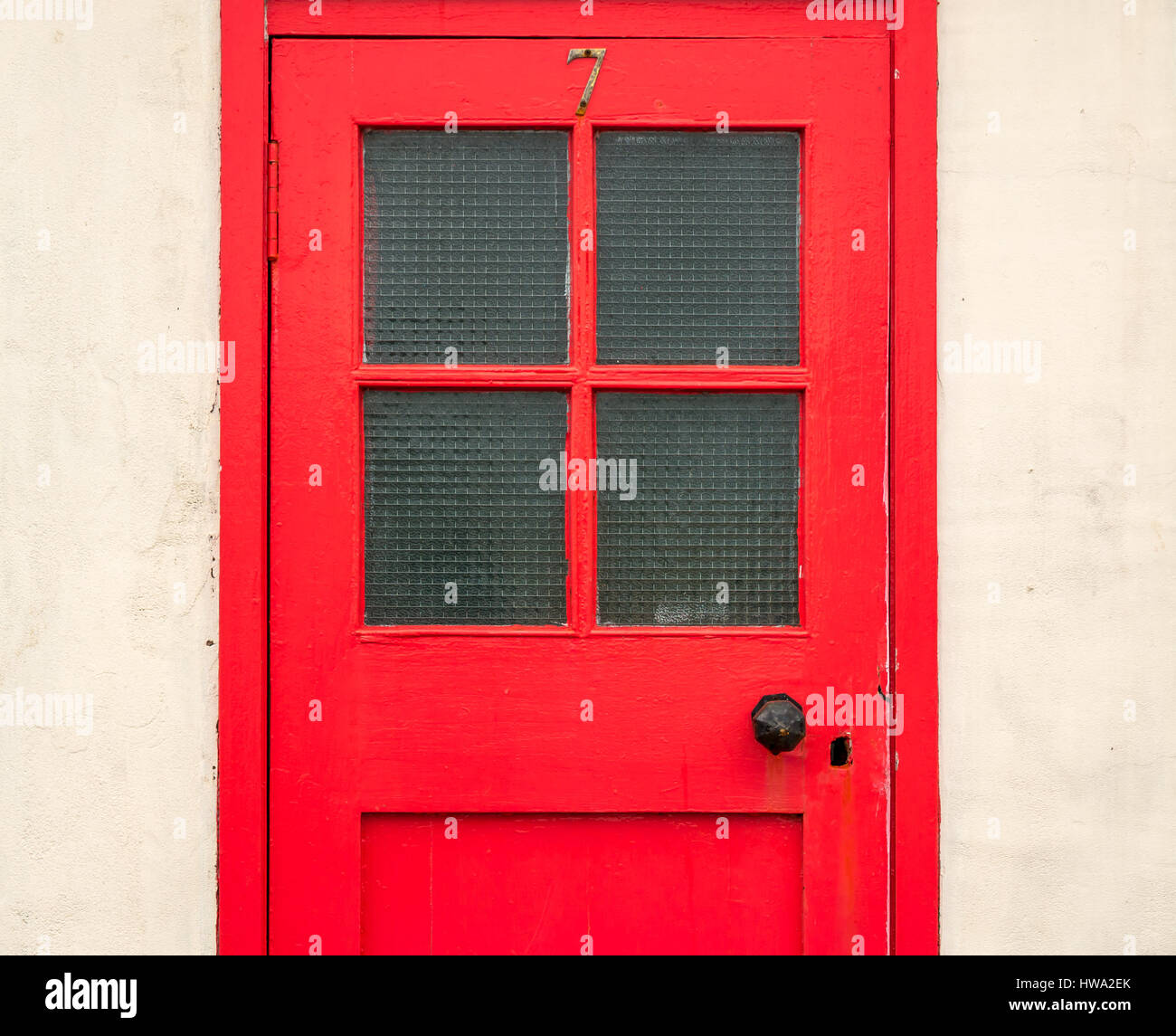 Nahaufnahme eines alten Rot lackiert Tür mit einer Nummer Sieben und Fensterscheiben in einer Stadt am Meer, North Berwick, East Lothian, Schottland, Großbritannien Stockfoto