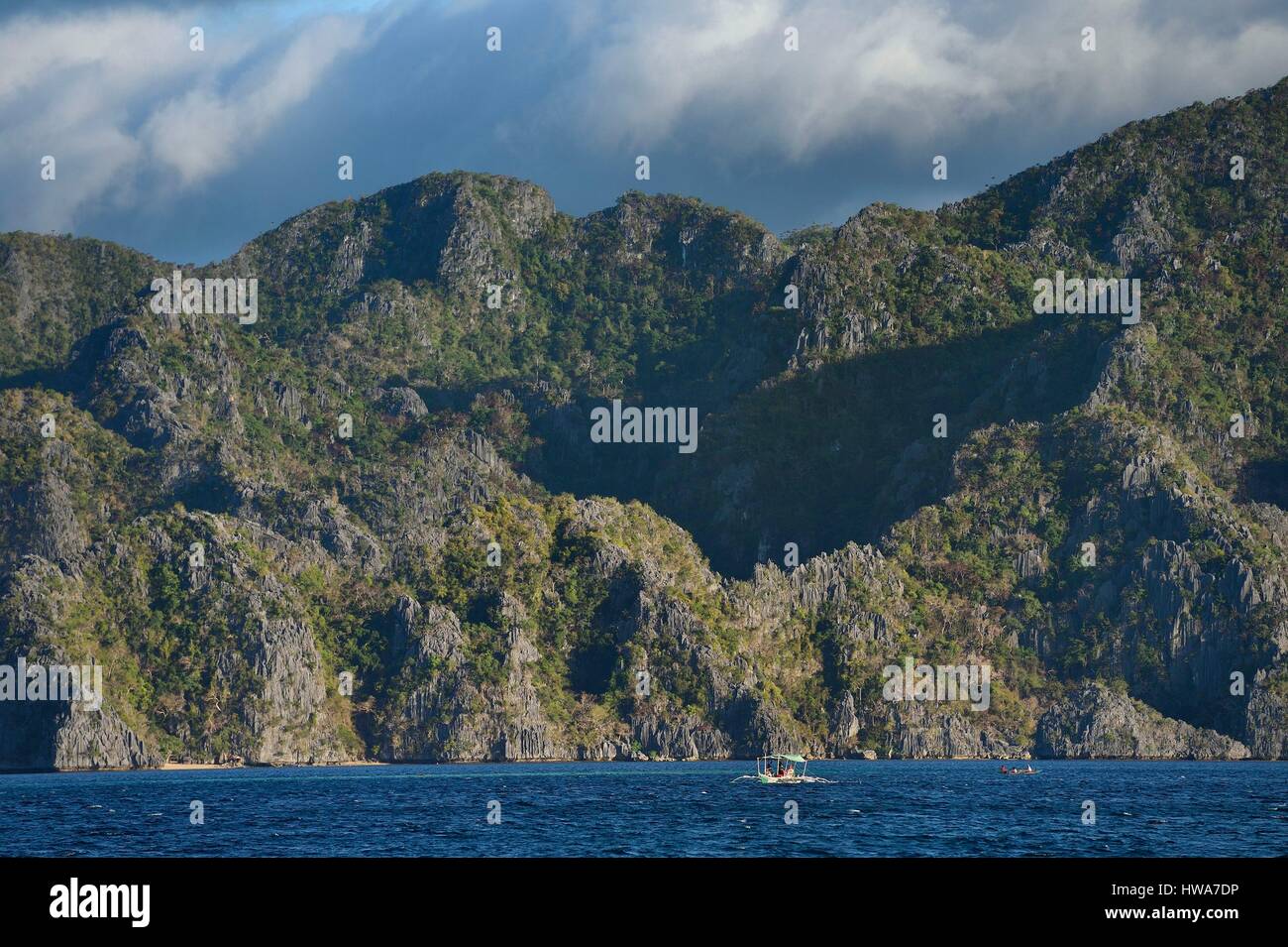 Philippinen, Calamian Inseln im nördlichen Palawan, Coron Island biotische Naturraum, Ausleger-Kanu unter riesigen Mauern von Perm Kalkstein der Jurassi Stockfoto