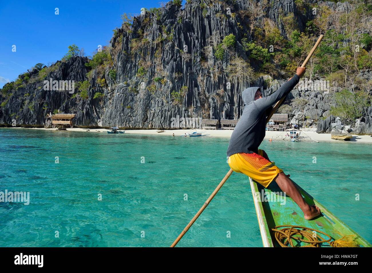 Philippinen, Calamian Inseln im nördlichen Palawan, Coron Island biotische Naturgebiet, Banul Strand unter riesigen Mauern von Kalksteinfelsen, Bootsmann Stockfoto