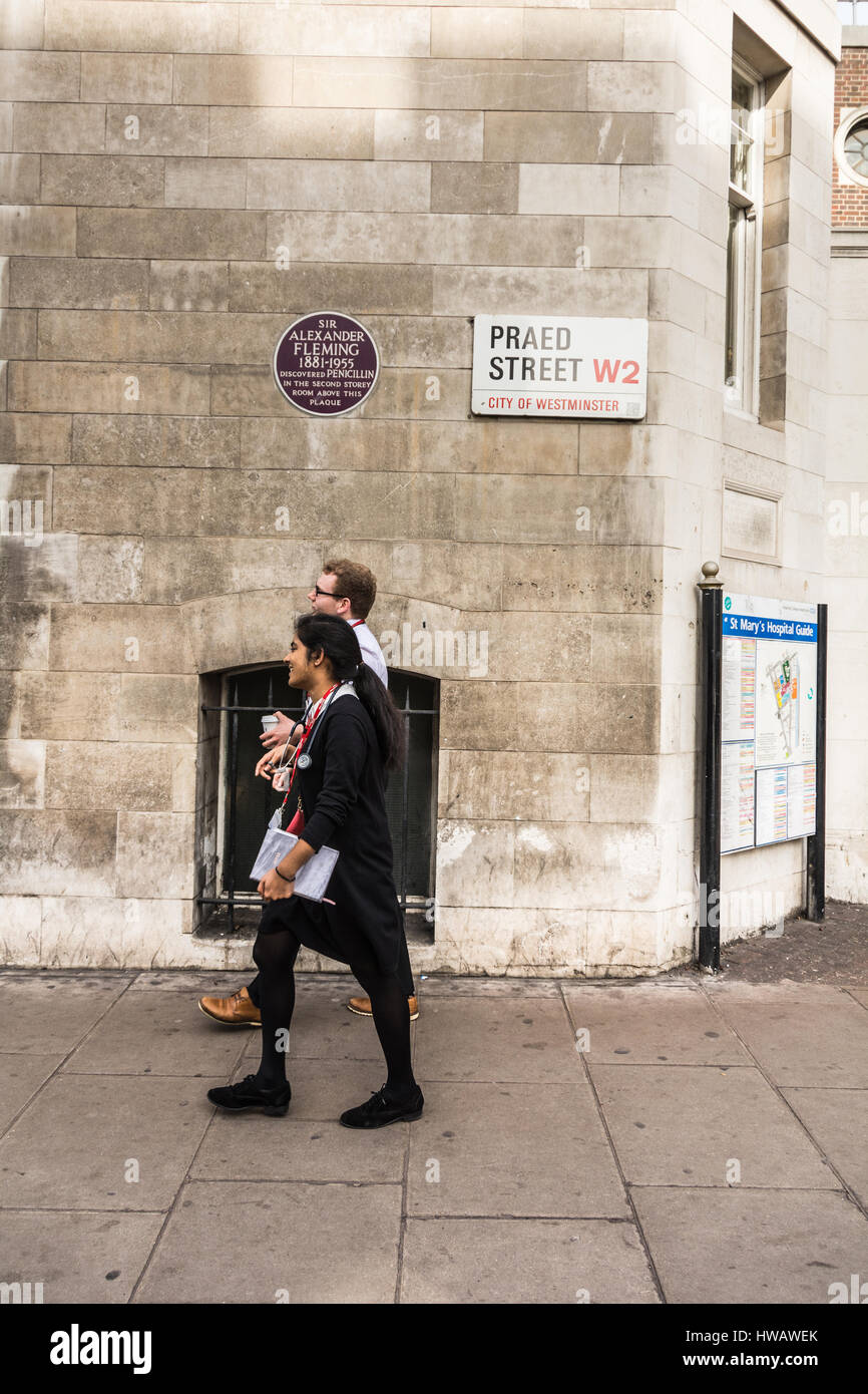 Ärzte gehen neben einer Plakette zu Sir Alexander Fleming vor dem St Mary's Hospital, London, Großbritannien Stockfoto