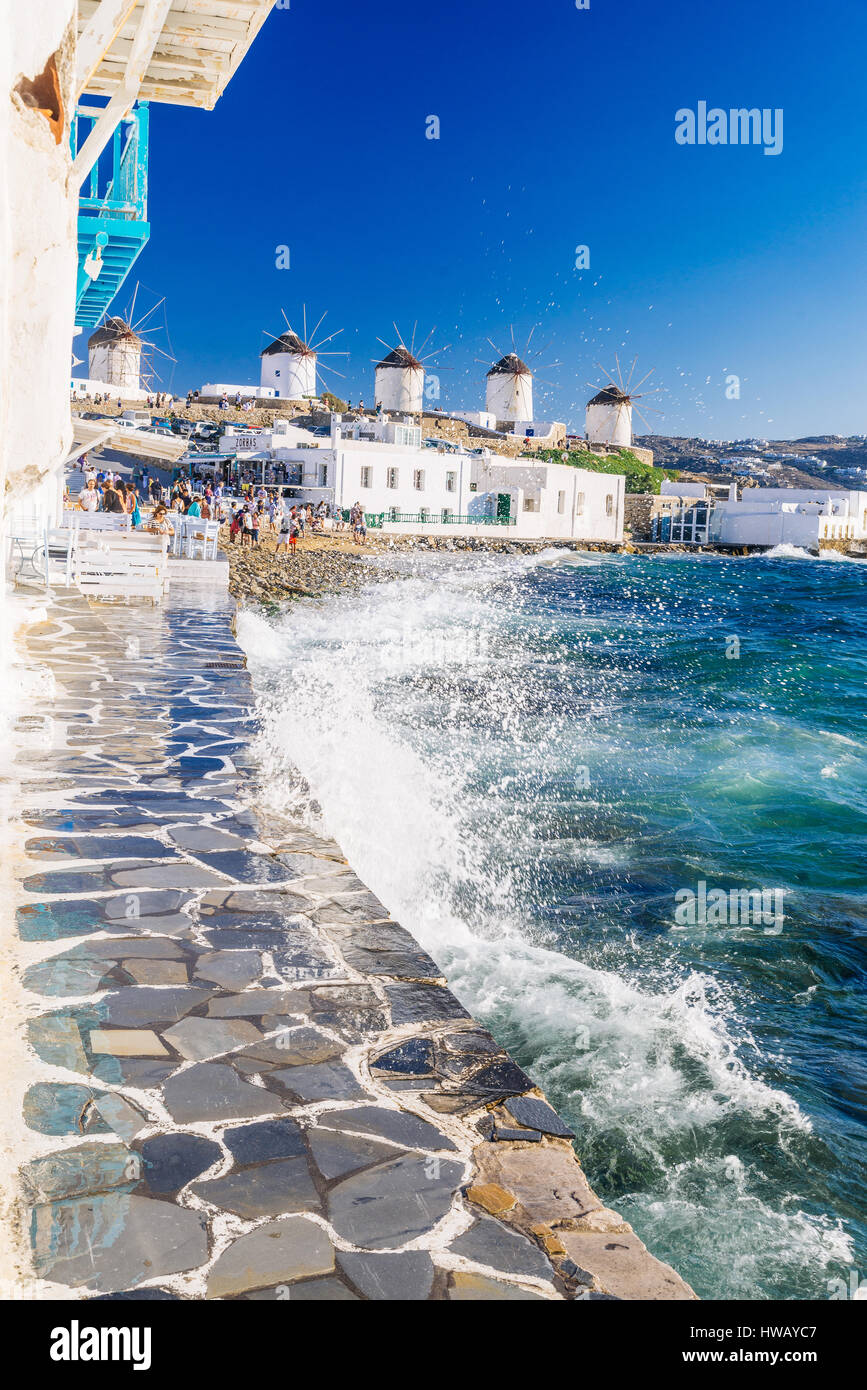 Plätschernden Wellen und berühmten Mykonos Windmühlen in goldenen Nachmittag Licht, Insel Mykonos, Kykladen, Griechenland Stockfoto